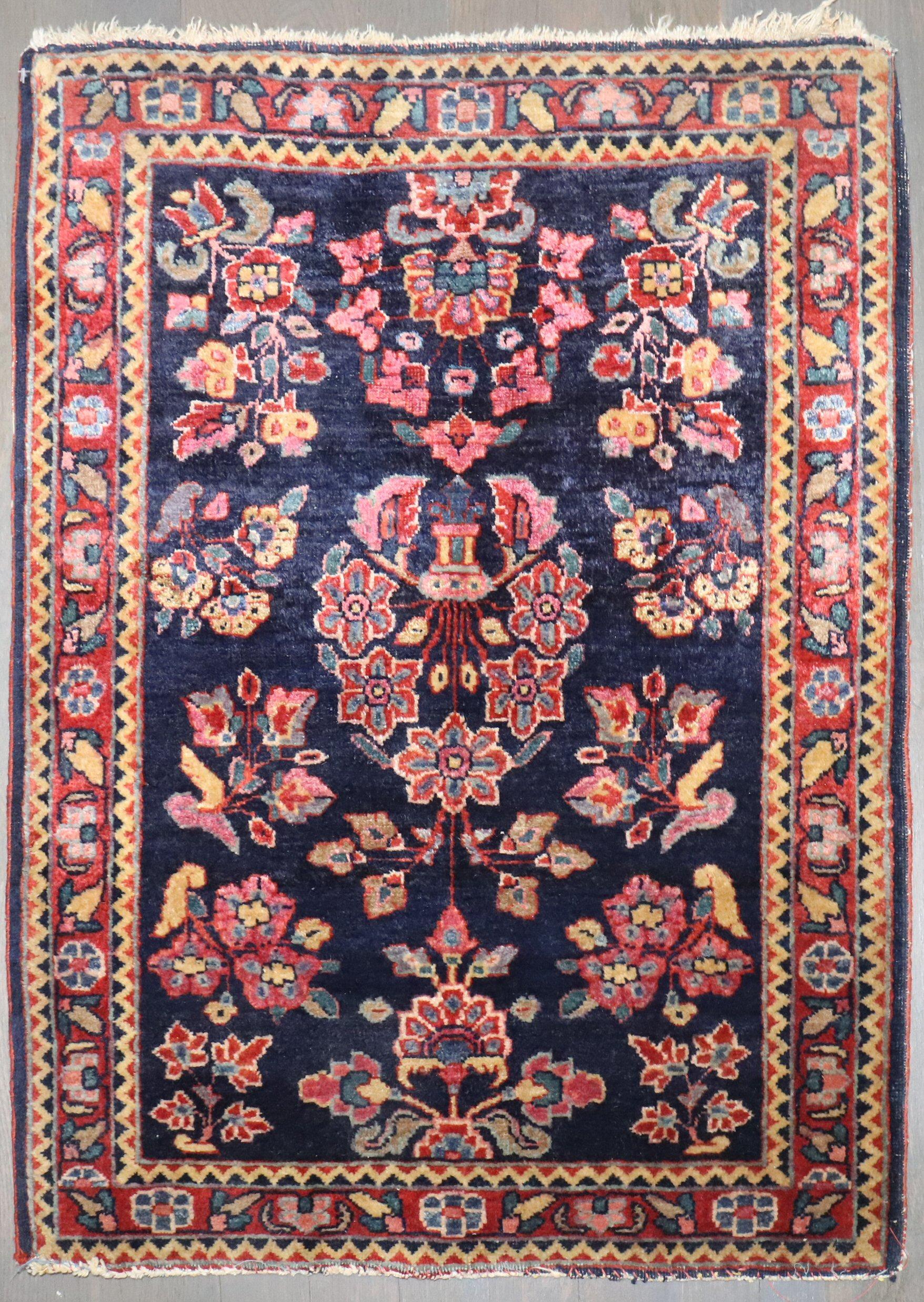 An authentic early 20th-century Sarouk carpet with a traditional formal design on a navy ground

Measures: 1'10