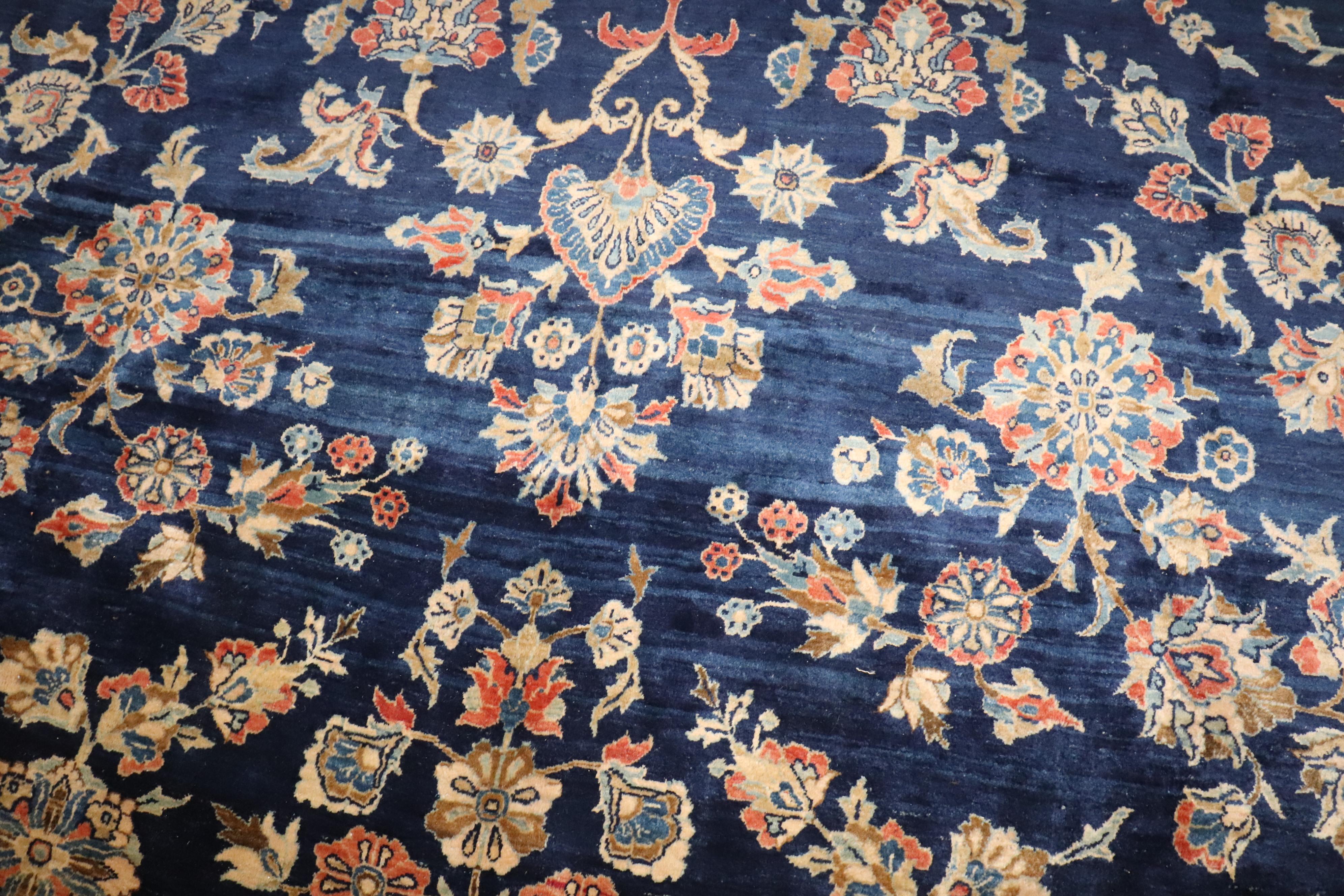 1910s Persian Sarouk rug woven with Manchester wool. An all-over sprayed floral design on a midnight blue field and terracotta floral shrub border

Details
rug no.	j4505
size	11' 6