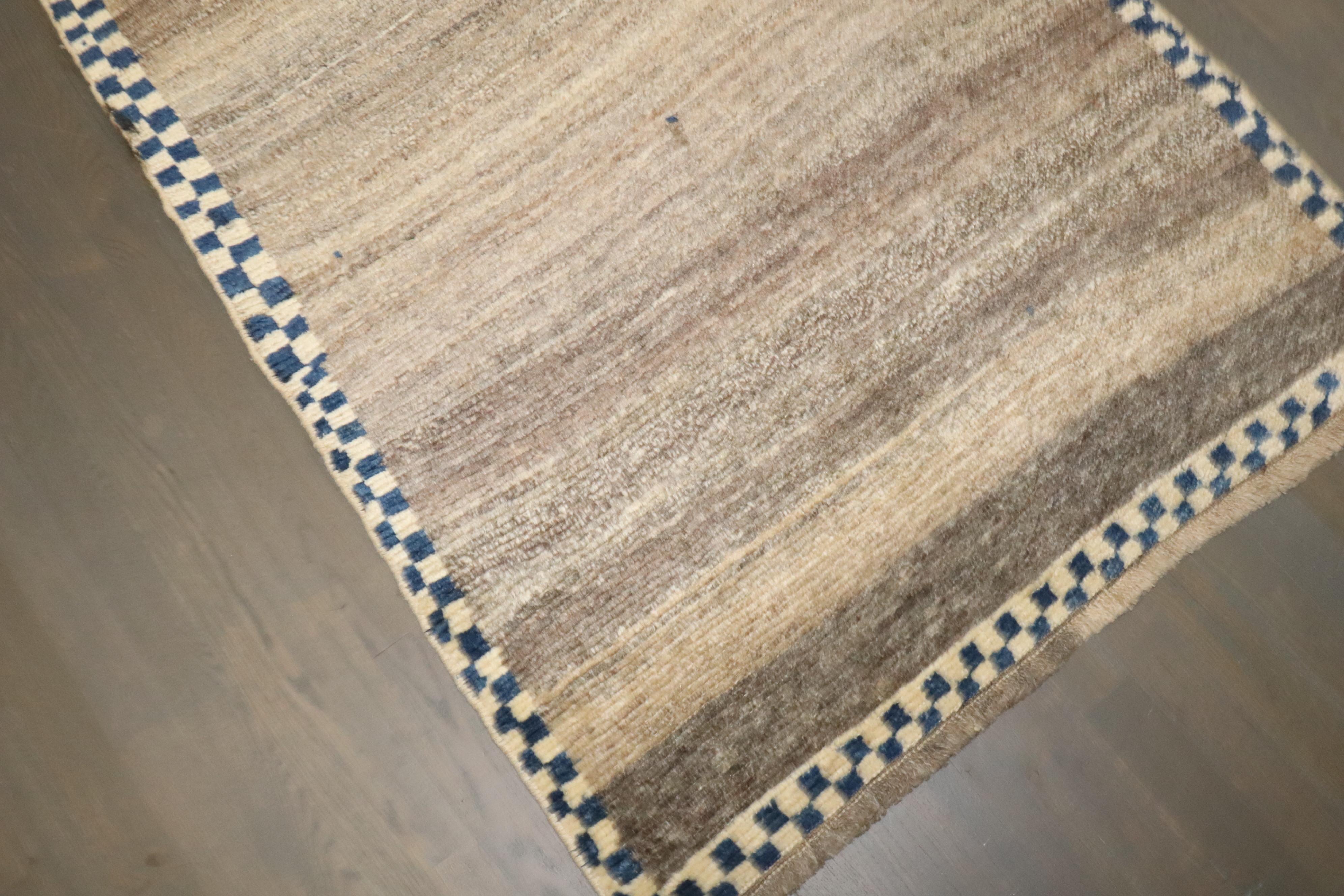 un runner Gabbeh persiano del terzo quarto del XX secolo con un campo marrone semplice circondato da un sottile disegno a scacchiera

Dettagli
rug no.	10766
dimensione	3' 2