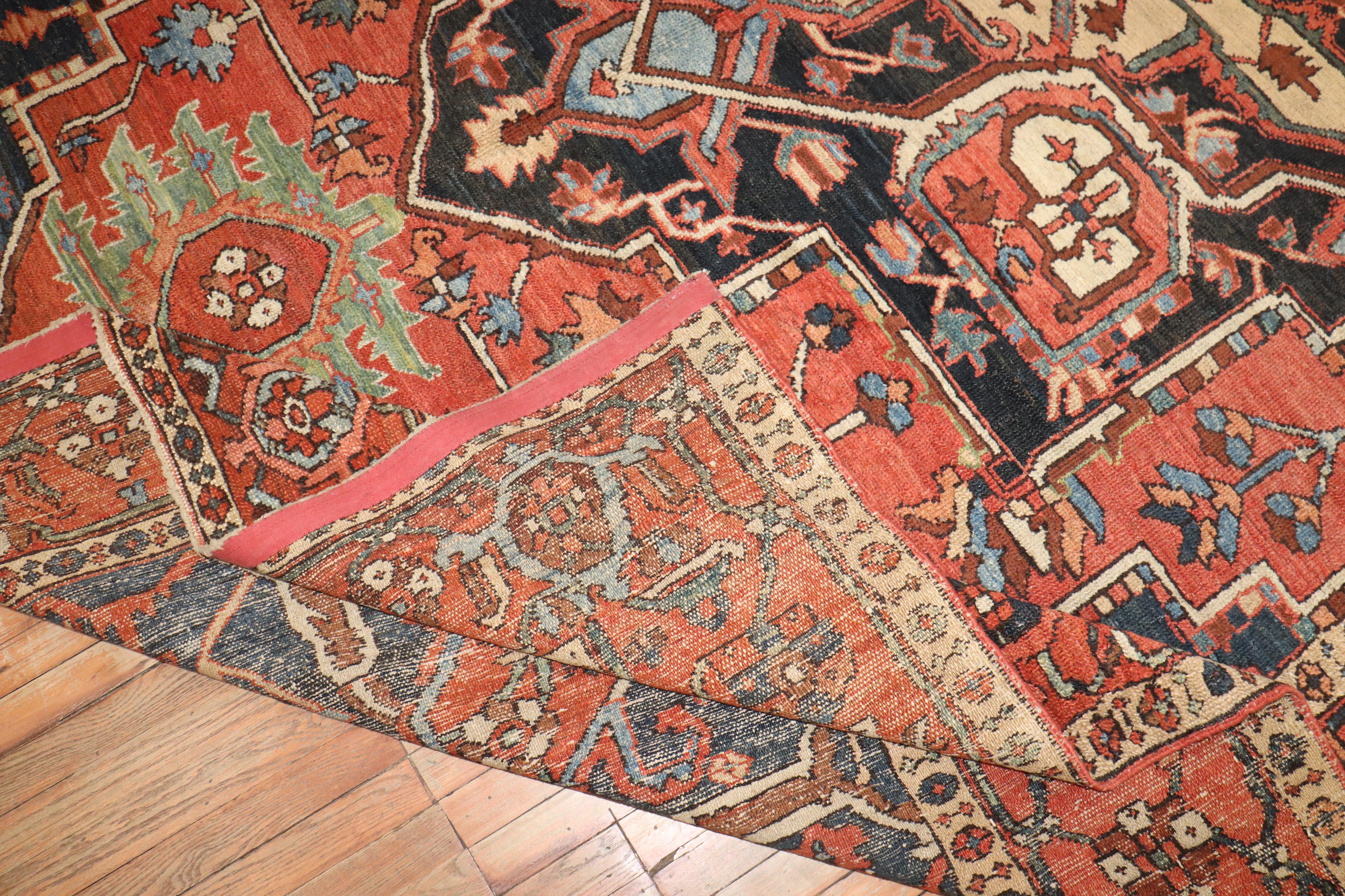 Rare tapis ancien traditionnel persan Heriz de taille 10 x 14. Champ et bordure orange, médaillon anthracite, accents kaki, bleus et verts 

circa 1920, mesure : 9'11