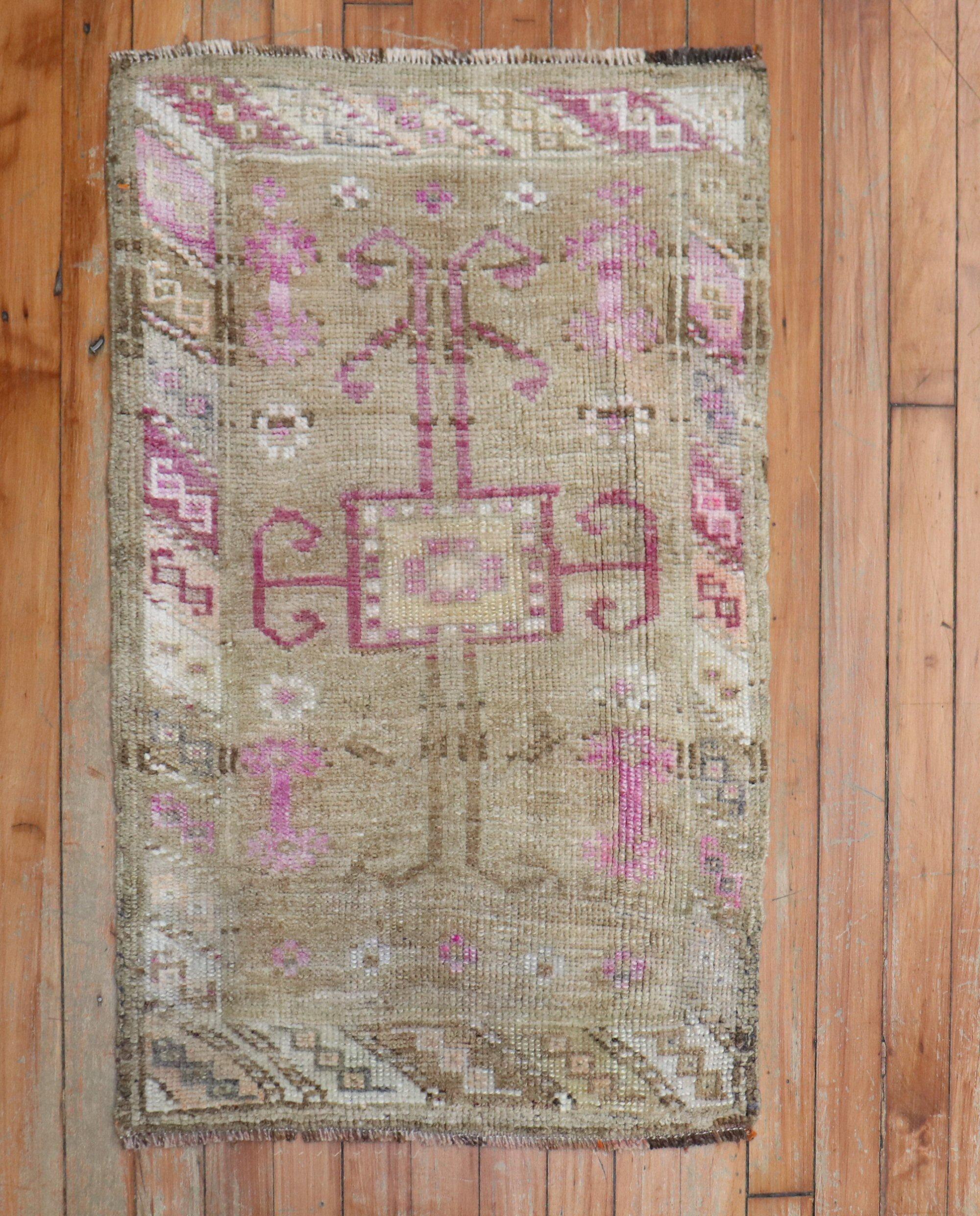 tapis turc miniature du milieu du 20e siècle avec des touches de rose sur un fond brun prédominant

Mesures : 1'9' x 2'9