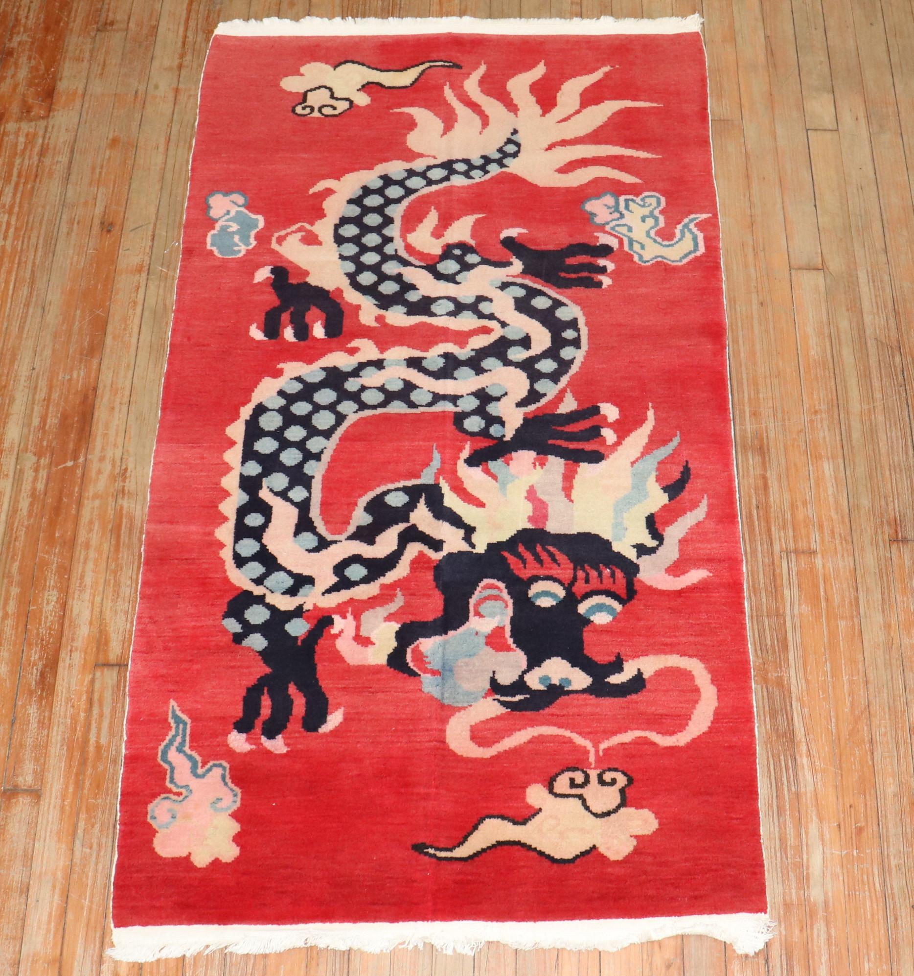 Tapis tibétain unique et coloré du 3e quart du 20e siècle avec un motif de dragon sur fond rouge.

Mesures : 3' x 5'7''.