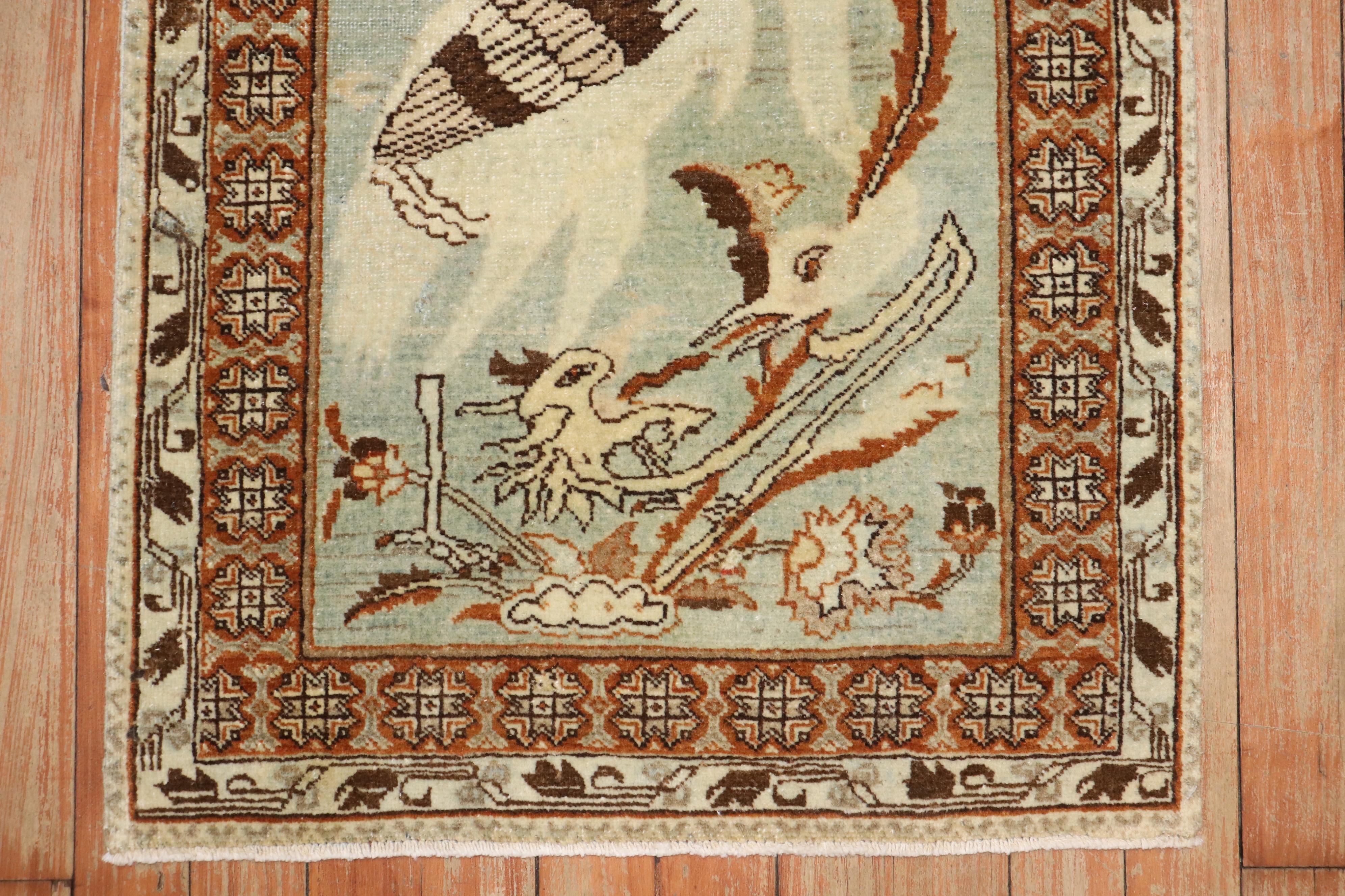 An early  20th century mat size Persian Tabriz rug depicting what looks to be a swan or rooster on a mint green ground. R

Measures: 1'9