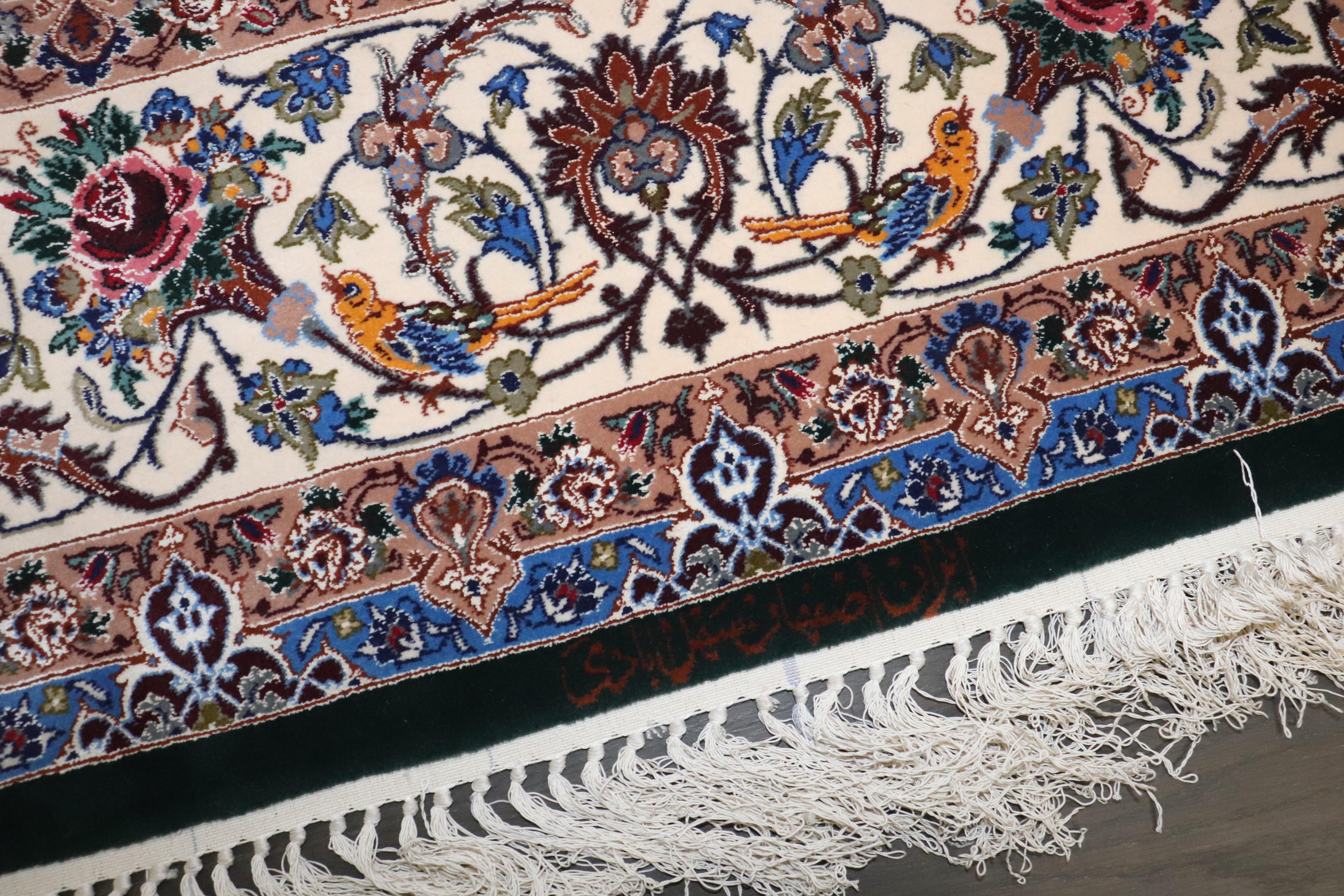 A mid-20th-century Persian Isfahan Prayer Carpet. The jade field with birds amongst a flowering vase, vinery, and a floral medallion beneath ivory spandrels is within a palmette and vine border. Signed, silk highlights and foundation. 483