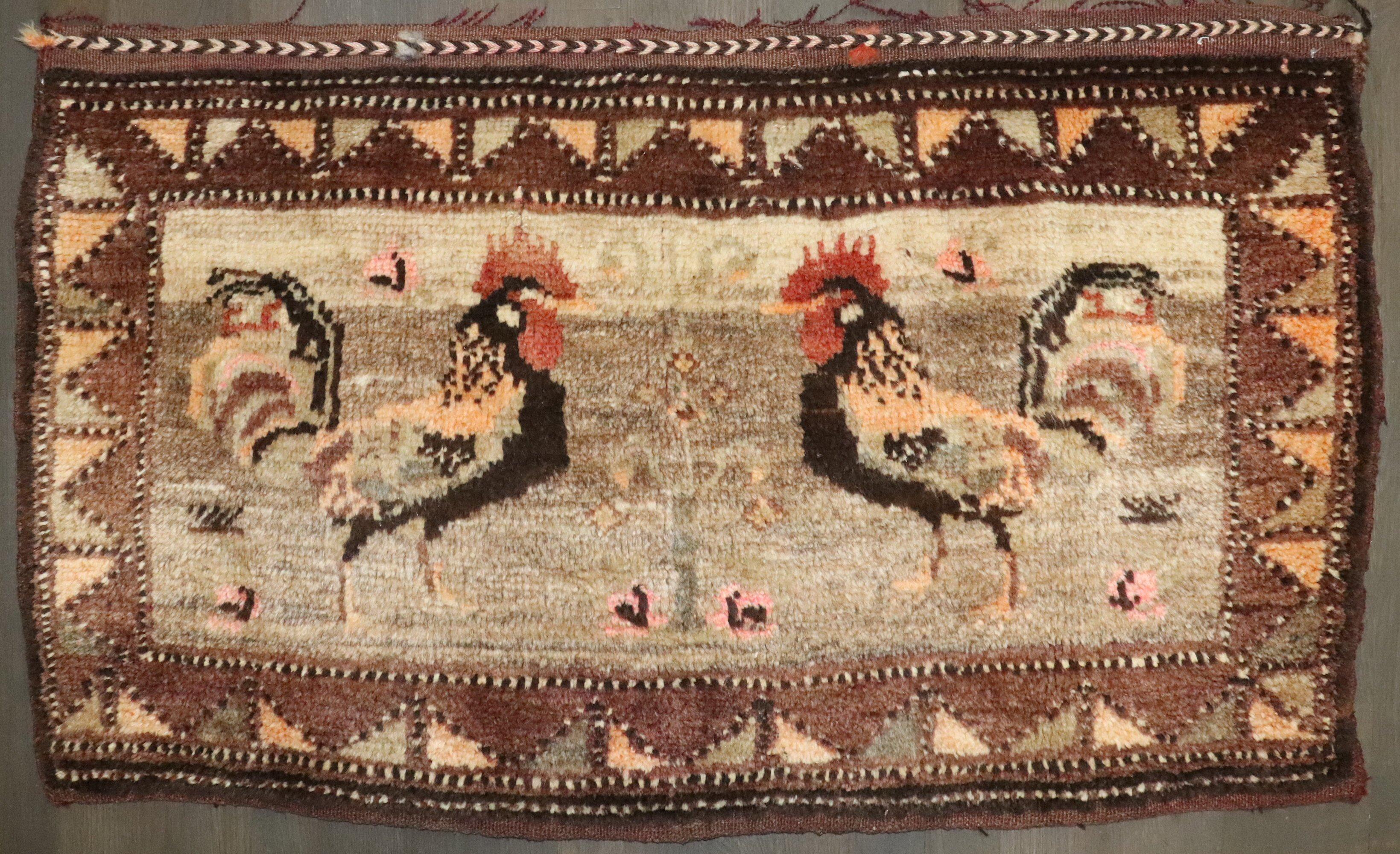 a mid 20th century Turkish Kars rug depicting 2 roosters on a camel color field

2' x 3'5''