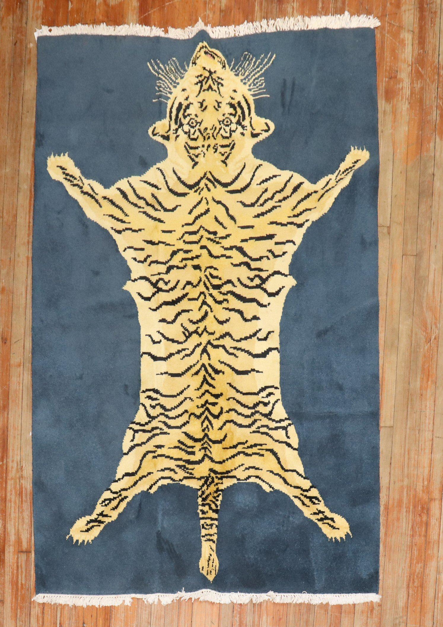 A late 20th-century Indian Rug with a large tiger flayed on a blue field.

4'9'' x 7'2''

