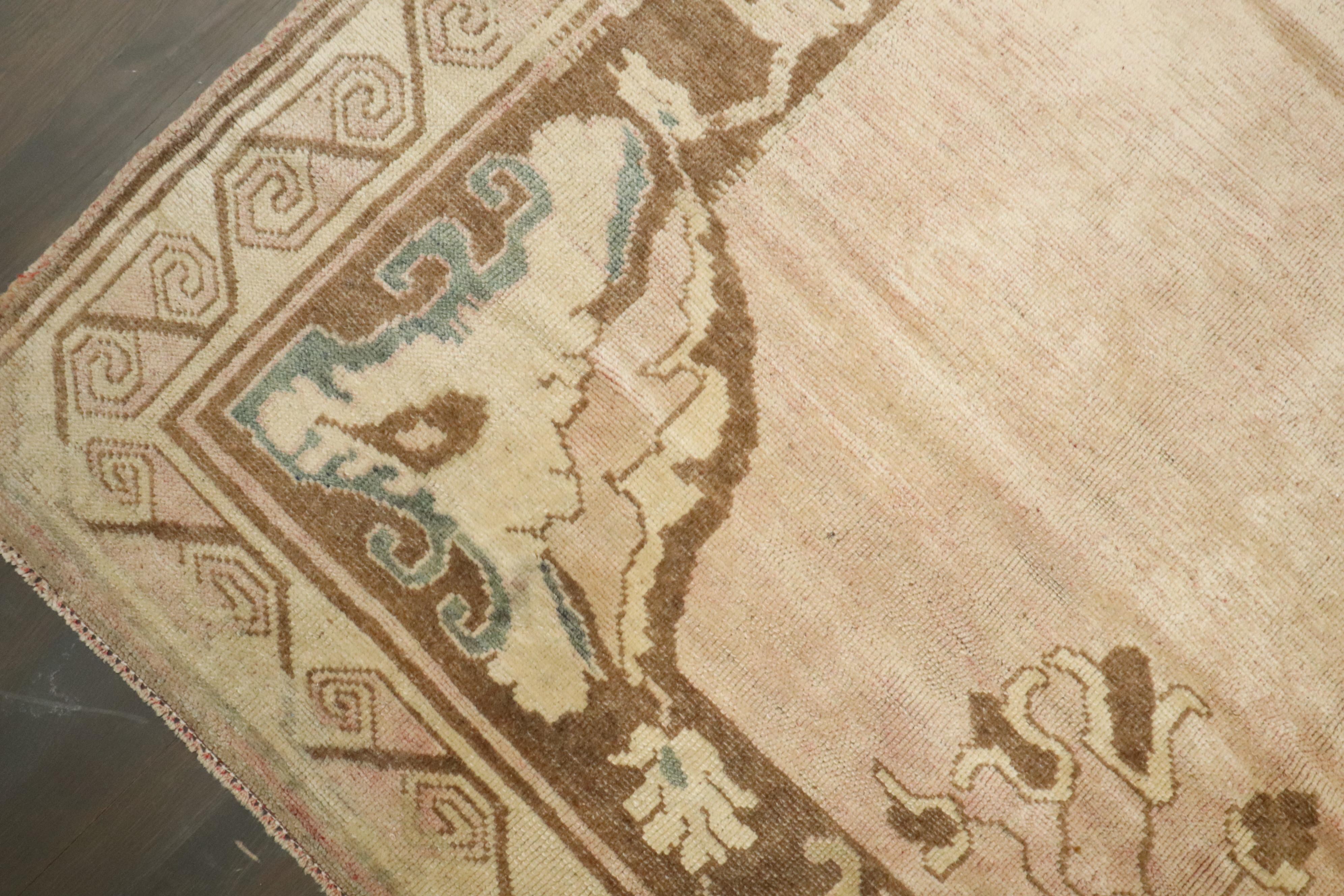 A One-of-a-kind vintage Turkish rug with a blush pink tone encased by an open field medallion motif.

Measures: 6'1'' x 12'3