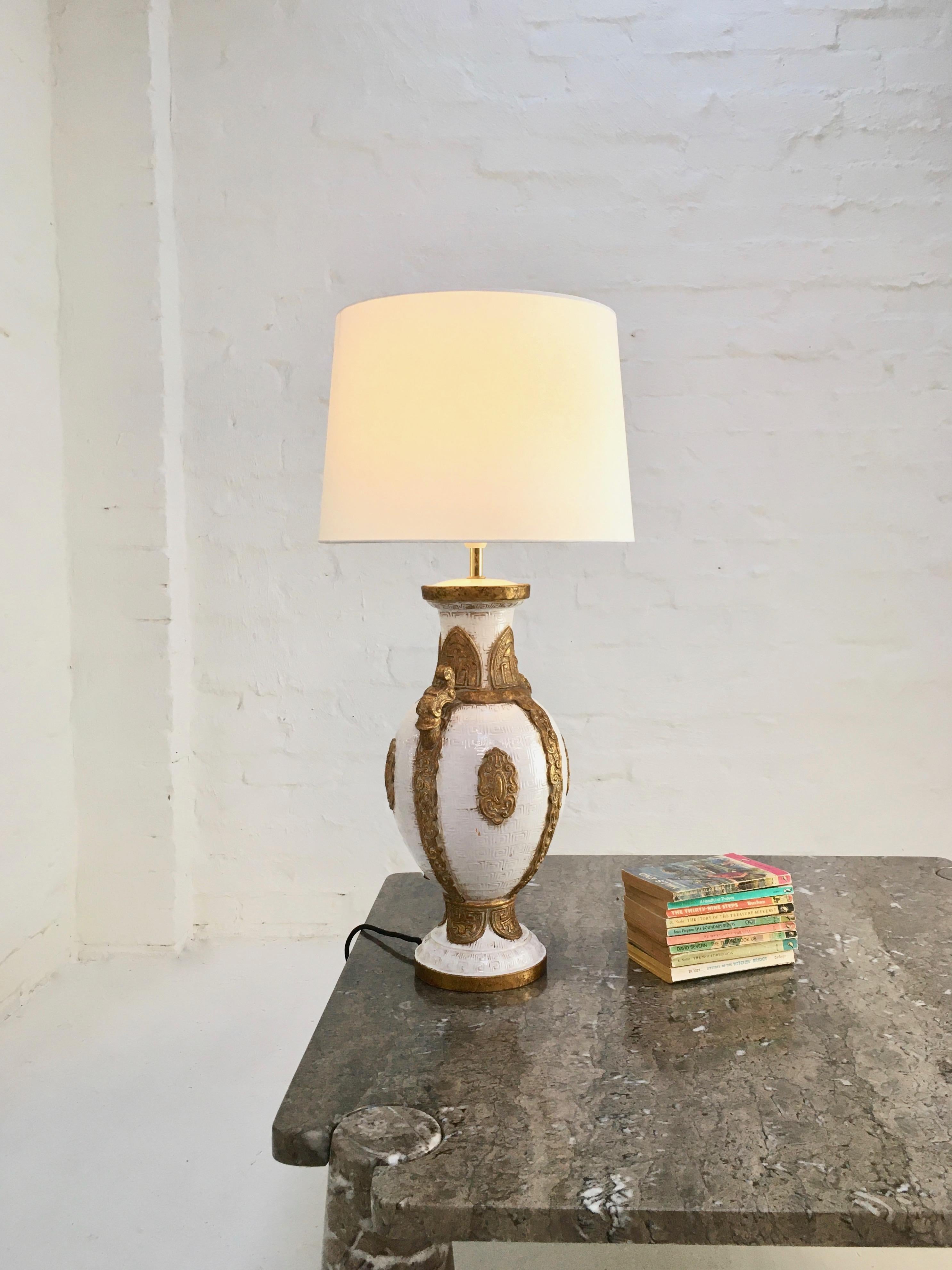 A large Hollywood Regency lamp with stylized decoration, standing 31.5 inches/80 cm tall to the top of the shade.

In keeping with the 1940s-1950s decorative style which saw large lamps move into the domestic market, this lamp is influenced by the