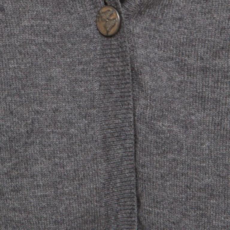 Diese Strickjacke von Zadig and Voltaire ist schlicht und stilvoll. Diese graue Strickjacke hat kurze Ärmel, einen Knopf auf der Vorderseite und ELVIS-Nieten auf der Rückseite. Dieses perfekt gestrickte Kleidungsstück ist einfach wunderbar genug, um