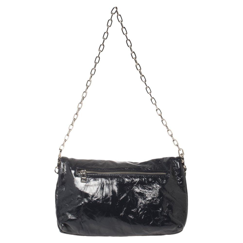 This Rock bag by Zadig & Voltaire is crafted from patent leather in a navy blue hue. It features a chain-link strap, a detachable shoulder strap, and a zip pocket at the back. The bag comes with a zip closure that opens to a canvas-lined interior