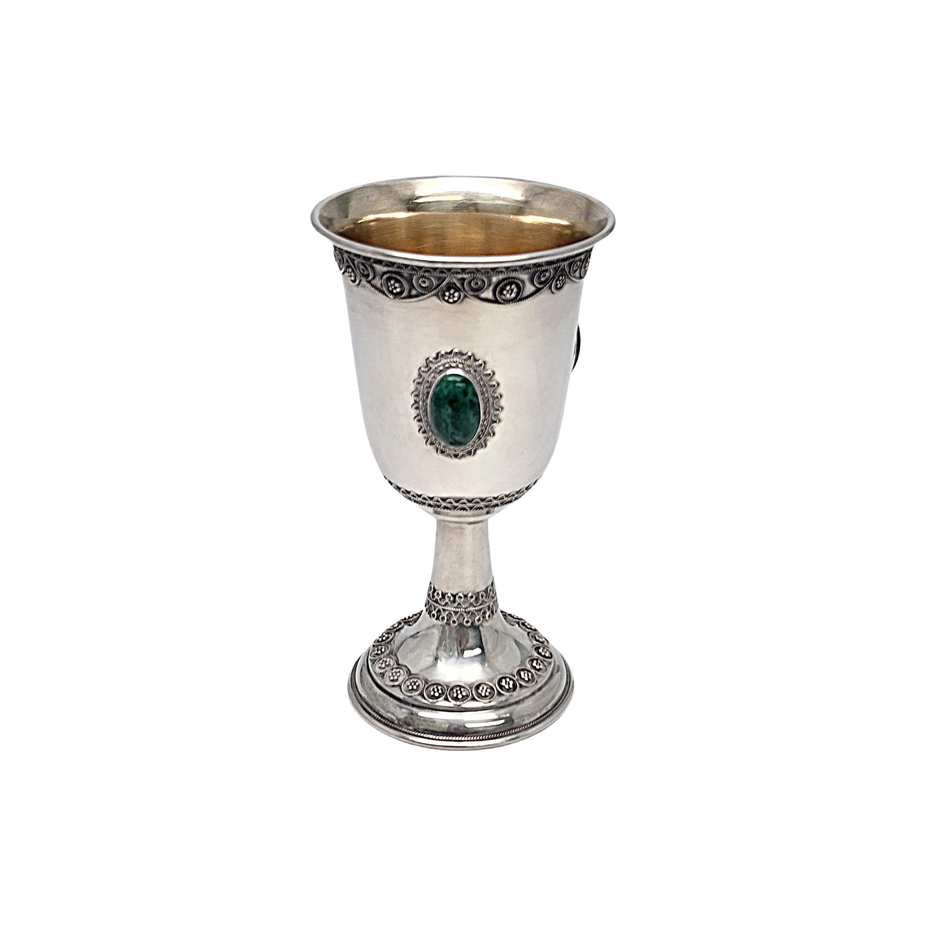 Sterling silver with gold wash interior Eliat stone kiddush cup goblet by Zadok of Israel.

No monograms or engraving.

With a gold wash cup interior, this cup/goblet features 3 bezel set green eliat stones and ornate filigree design accents. Eliat