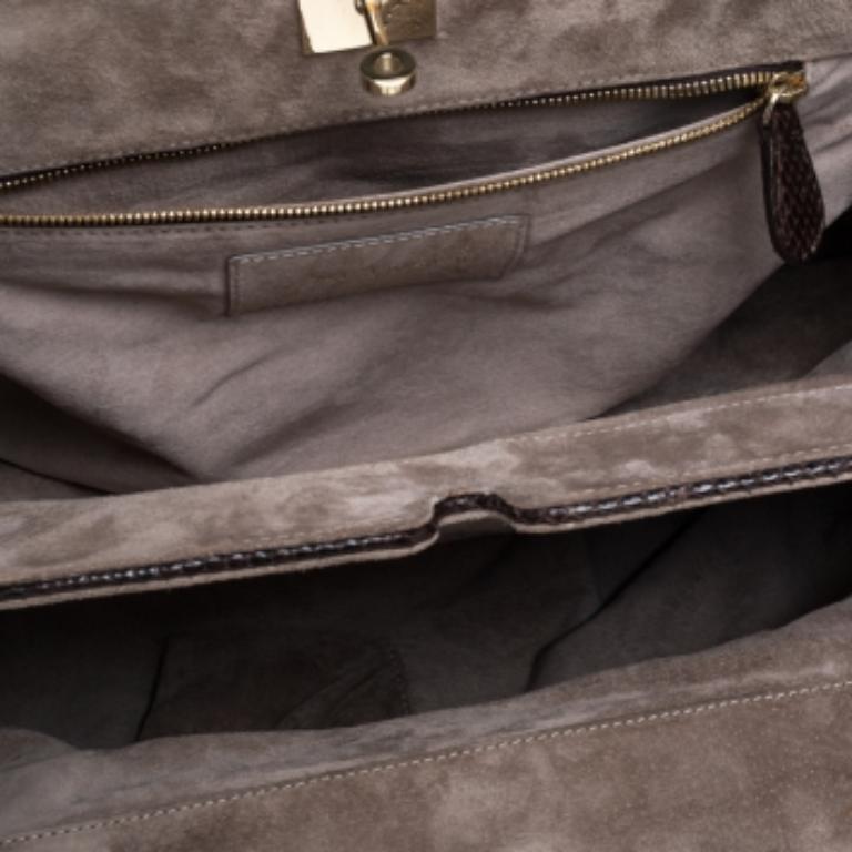 This Zagliani Puffy has all the details that make a bag prized. The bag has been crafted by hand from python leather and lined with suede on the insides. It has gold-tone hardware and two top handles for you to easily parade it. The grand metallic