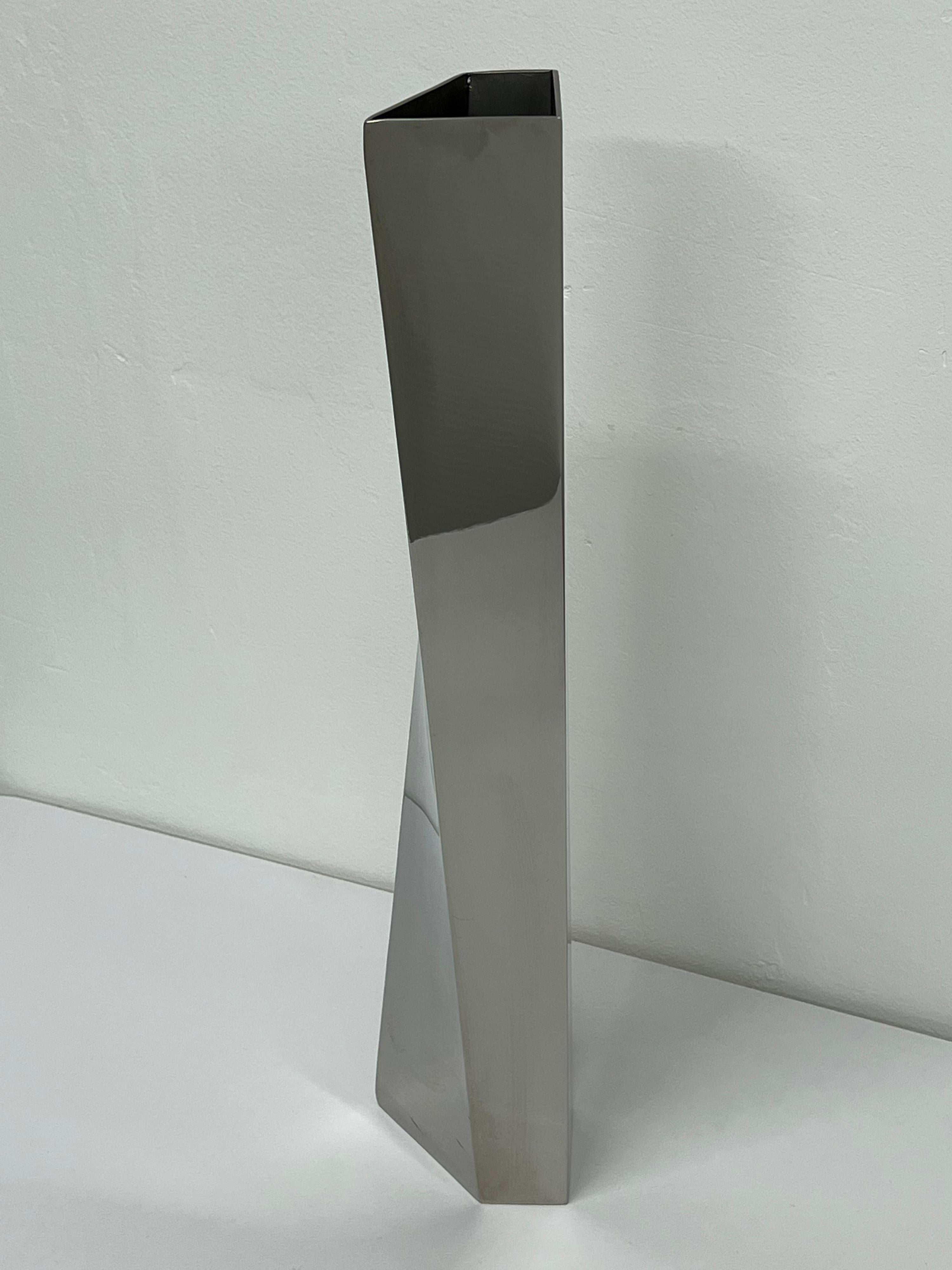 Zaha Hadid Crevasse flower vase for Alessi, 2005.

A vase cut from a single block of steel and scored along two diagonal lines, Crevasse by Zaha Hadid for Alessi creates a warped, inverted surface. With a force similar to that of an arctic
