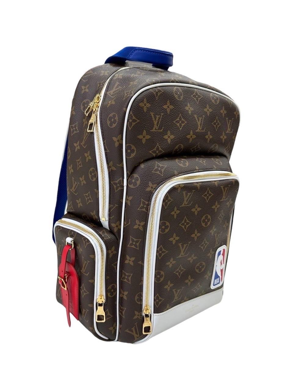 Zaino firmato Louis Vuitton, Limited Edition Backpack NBA, misura GM, realizzato nella classica tela monogram con inserti in pelle bianco e hardware dorati. Dotato di una chiusura superiore richiudibile da una zip, internamente rivestito in tela