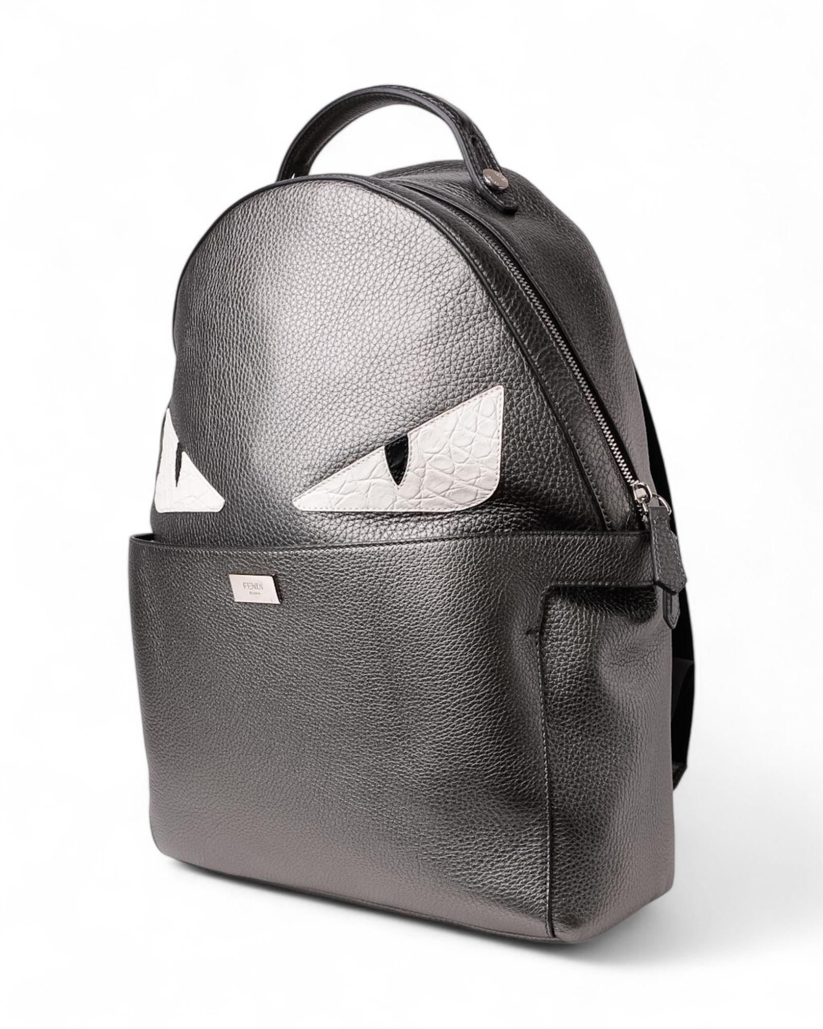 Zaino firmato Fendi, modello PELLE Monster, inella misura MM, è realizzato in pelle martellata grigia con hardware argentati che aggiunge un tocco di eleganza discreta. La fermeture à glissière avec deux curseurs garantit praticité et sécurité,