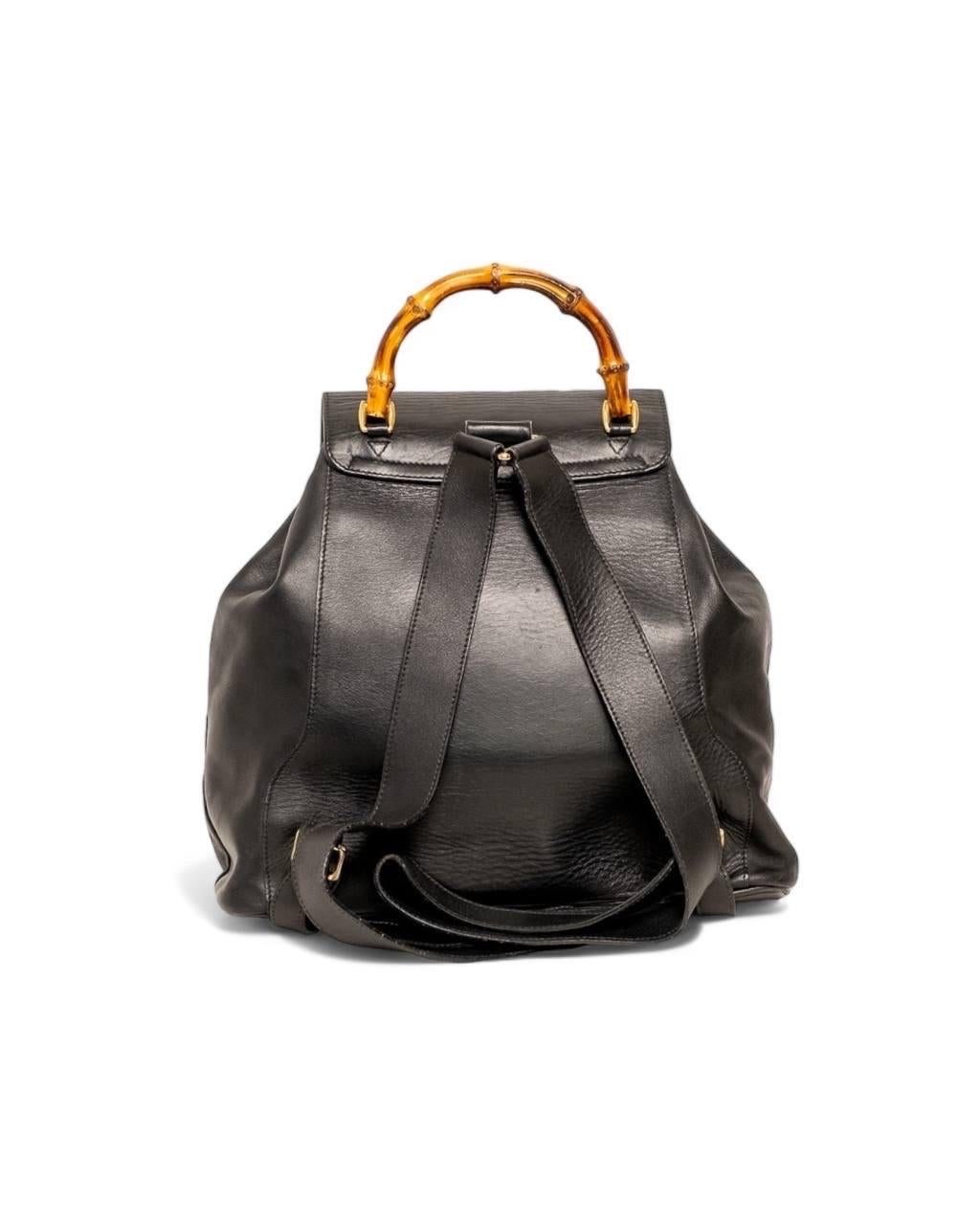 Zaino firmato Gucci, modello Bamboo, misura MM, realizzato in pelle nera con hardware dorati. Dotata di una patta esterna superiore con chiusura ad incastro e di una chiusura interna con coulisse. Internamente rivestito in tessuto tono su tono,