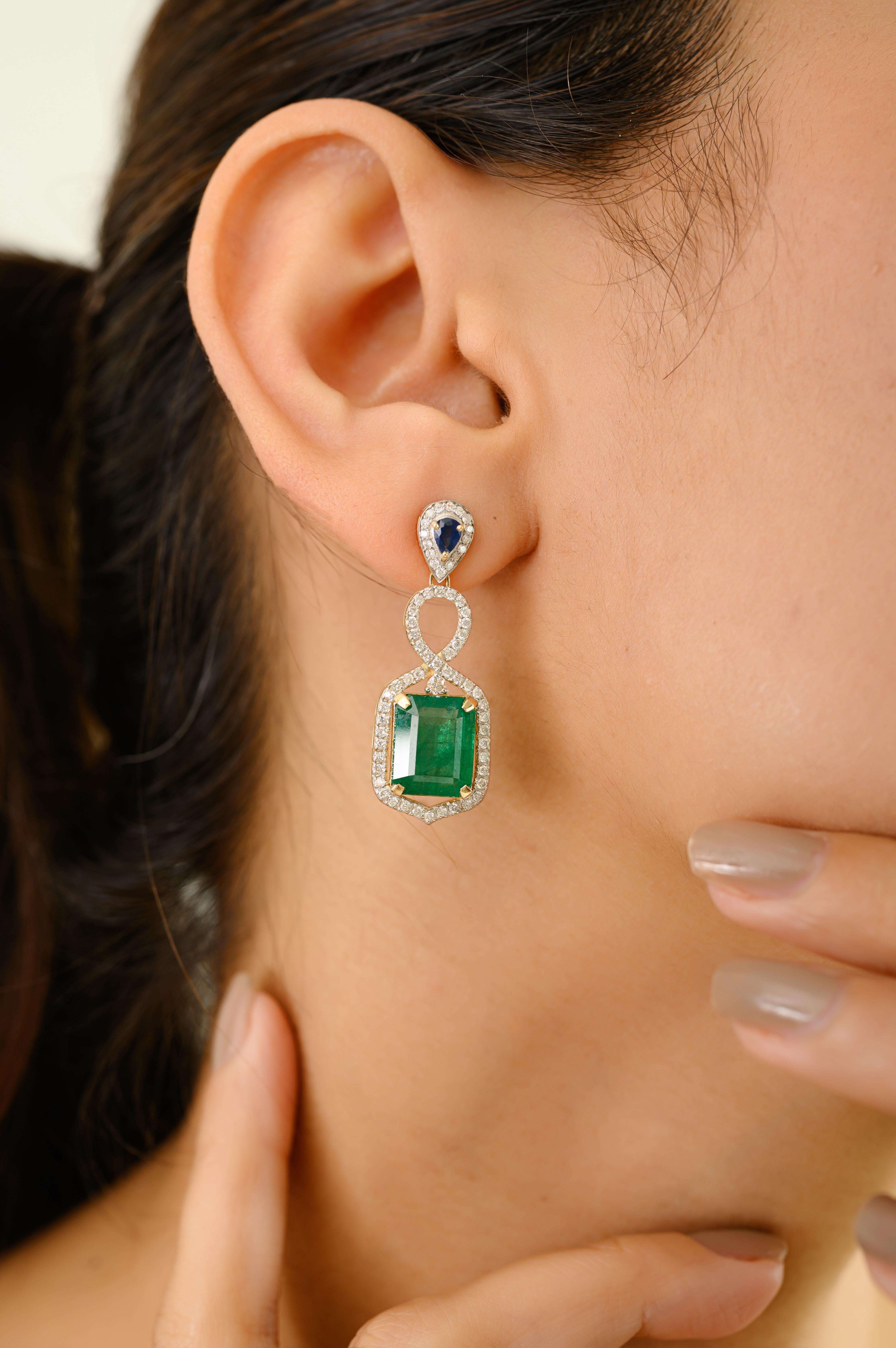 Radiating timeless sophistication, these exquisite drop earrings are crafted in 14k yellow gold and feature a stunning combination of vibrant gemstones. At the top, a deep blue sapphire anchors the design with a regal teardrop silhouette, leading