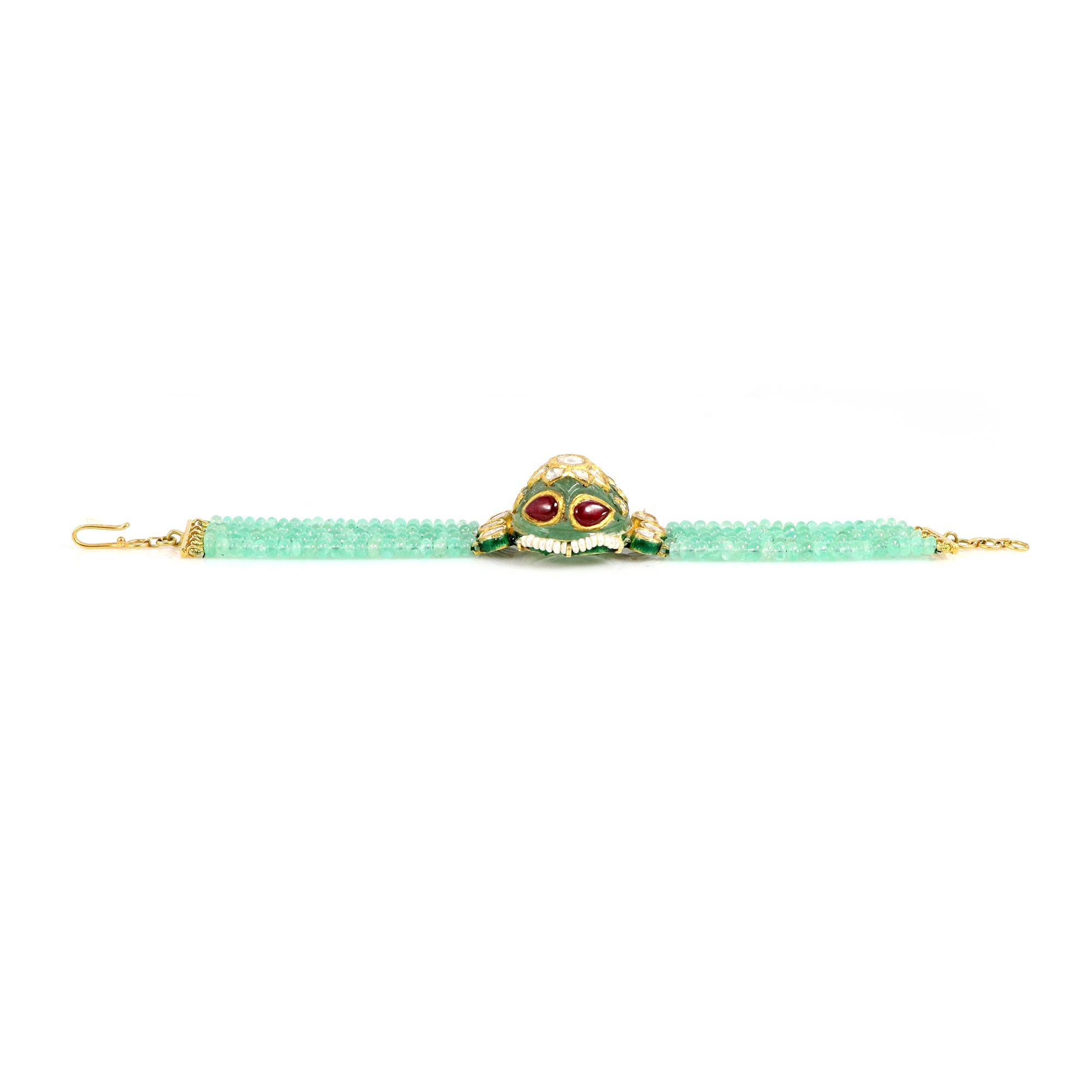 This is an elegant carved Zambian Emerald bracelet adorned with mesmerizing rubies and lustrous pearls and enameling in the back. Handcrafted with meticulous attention to detail, this stunning piece is a testament to timeless elegance. The vibrant