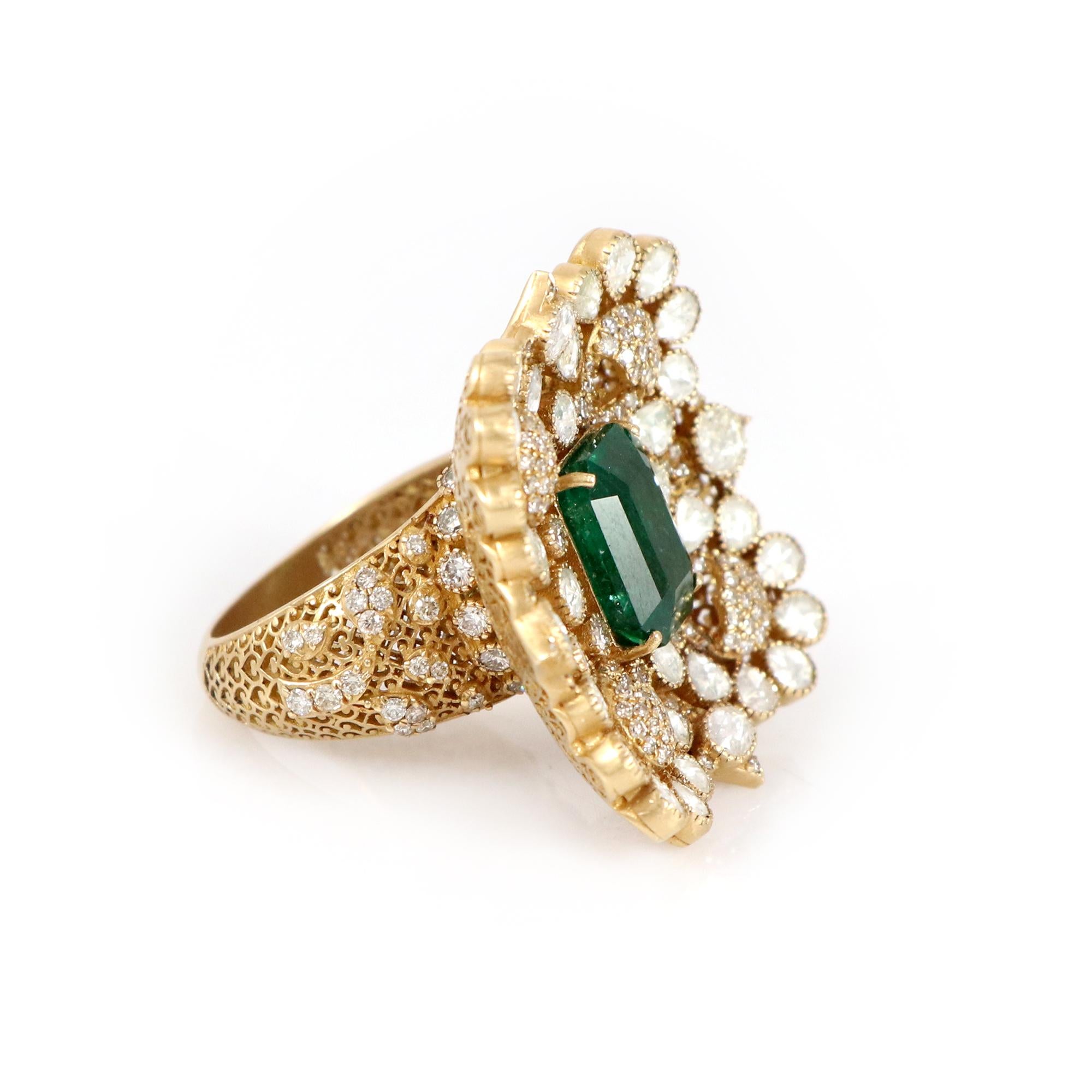 Introducing our timeless 18K yellow gold ring, graced by a captivating emerald at its core and elegantly encircled by rose cut diamonds, exuding unparalleled refinement. The lush green of the Zambian emerald symbolizes abundance, while the delicate