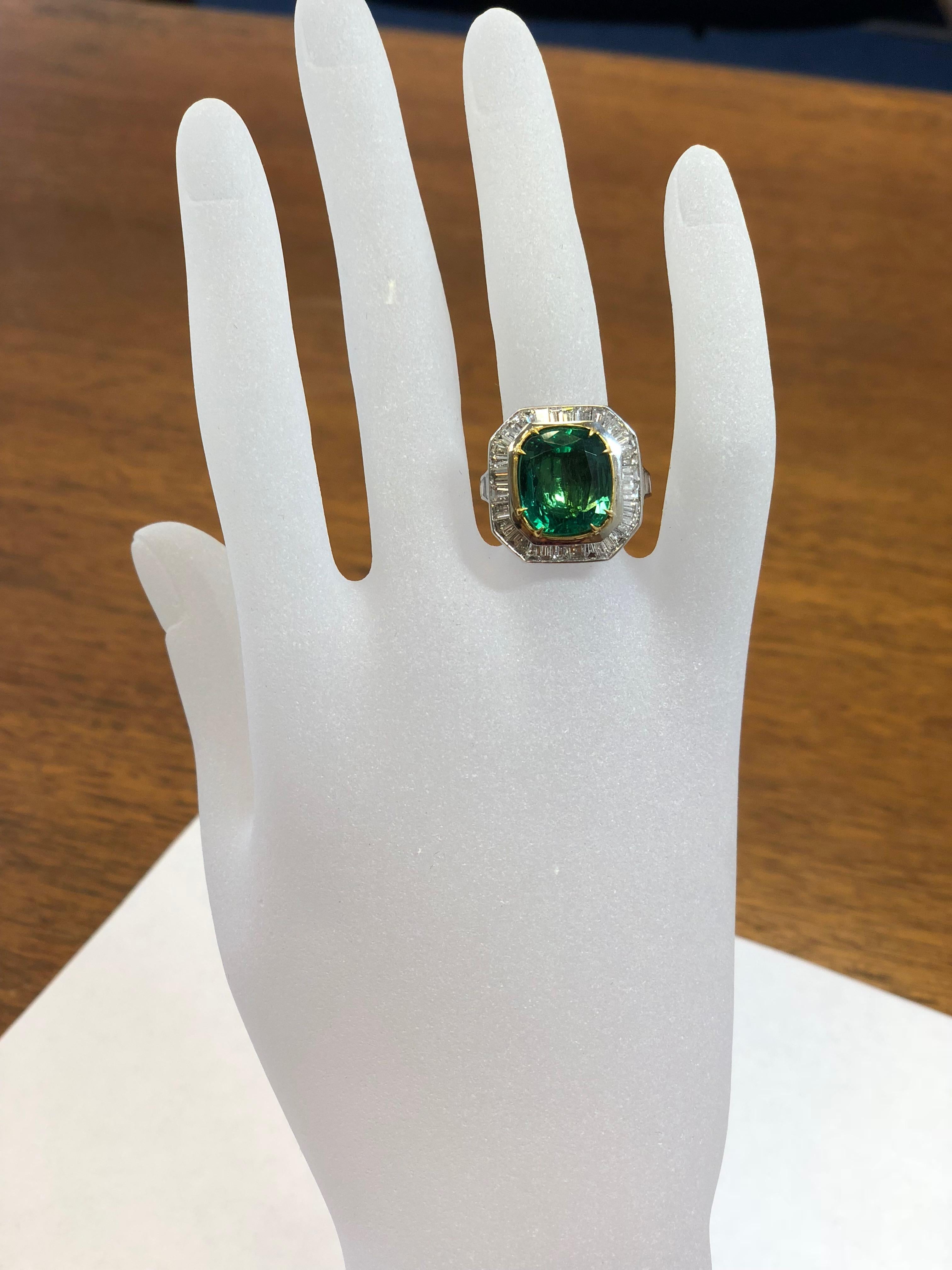 Stunning 6.98 carat Zambian emerald cushion cut with beautiful diamond baguettes surrounding the stone and on the band.  Gorgeous deep green color and luster to the emerald with good quality white diamonds.  The shape of the cushion is ideal for