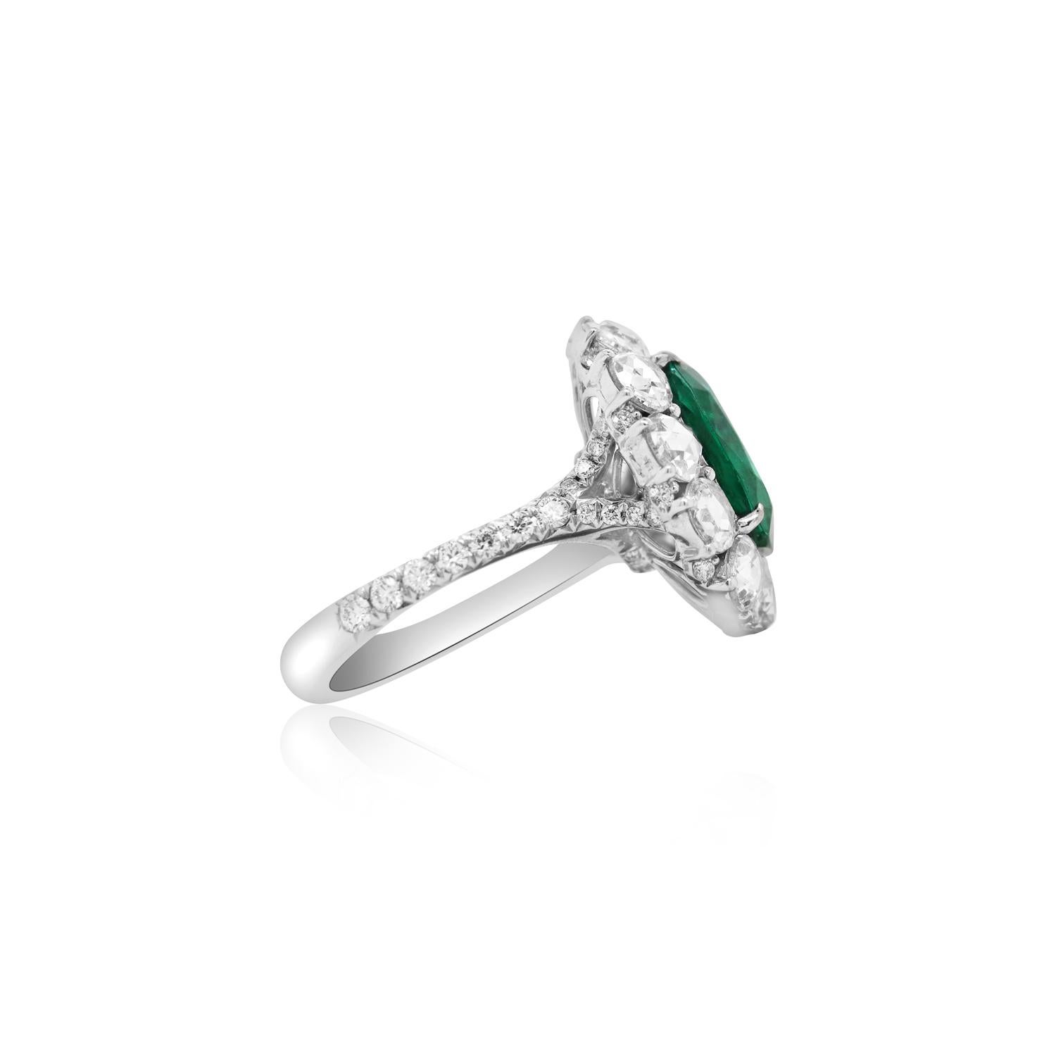 Metal: 18K White Gold

Center Stone: 1 Cushion Cut Zambian Emerald at 4.82 Carats - Measuring 12 x 10 millimeters

Diamond Details: 12 Rose Cut Round White Diamonds at 2.49 Carats Total Weight

Ring size: Customizable

Fine one-of-a-kind