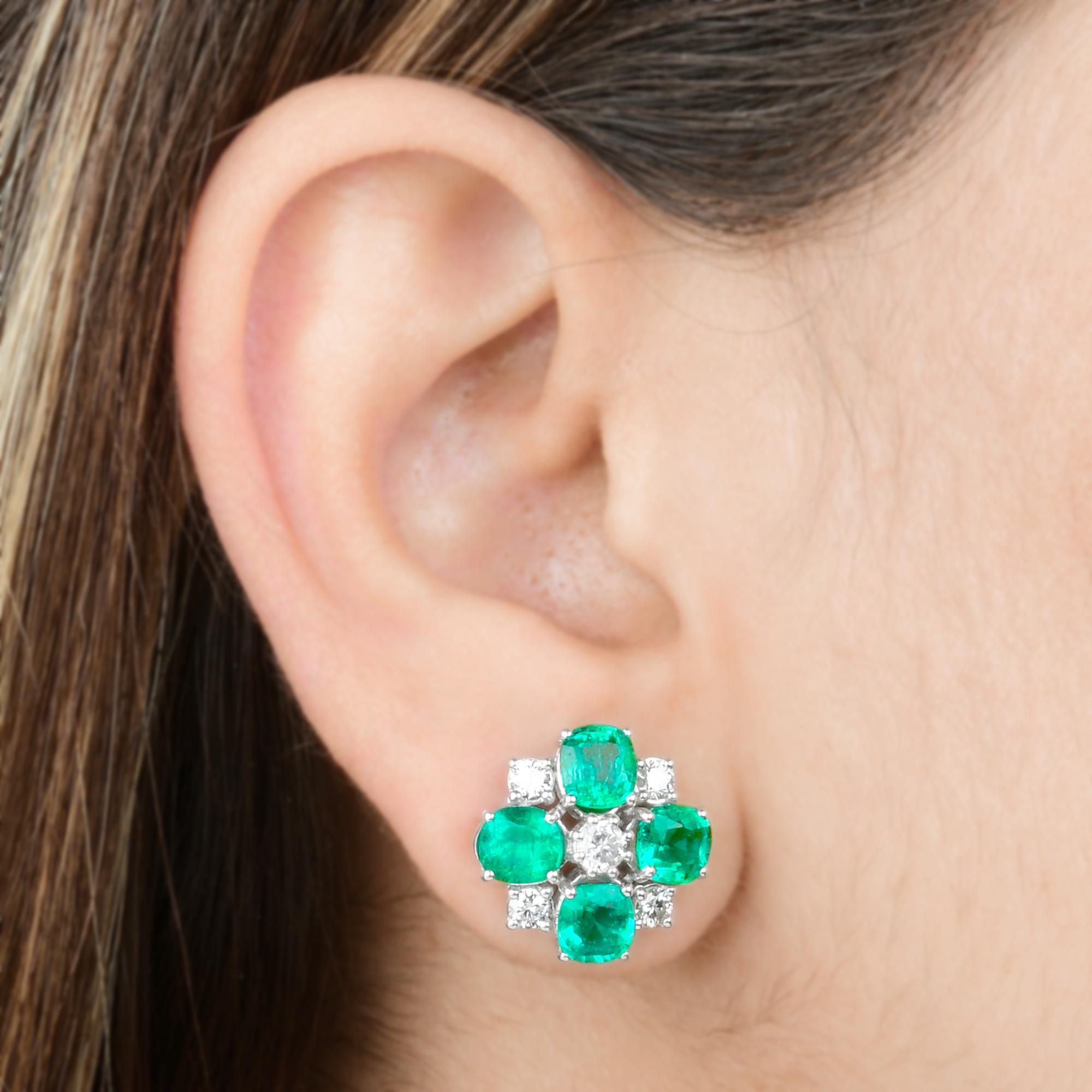 Questi orecchini a perno con diamante smeraldo dello Zambia in oro bianco 14 carati sono caratterizzati da smeraldi a taglio cuscino e diamanti a taglio rotondo incastonati in perni di forma quadrata con smeraldo incastonato agli angoli.
Gli