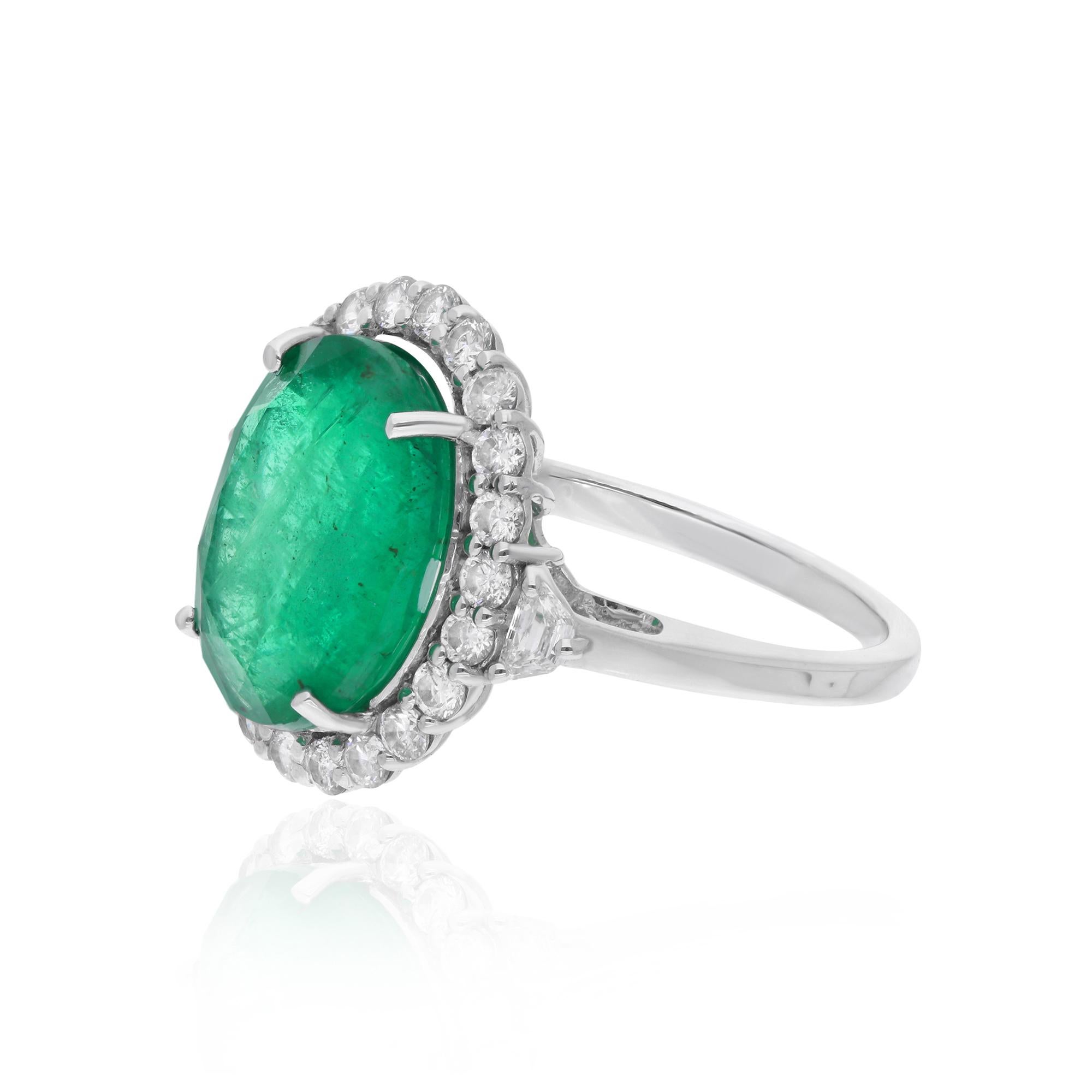 The intricate details of the 14 Karat White Gold band further enhance the ring's exquisite beauty. The cool, silvery tones of the white gold provide the perfect backdrop for the vivid green of the emerald and the scintillating sparkle of the