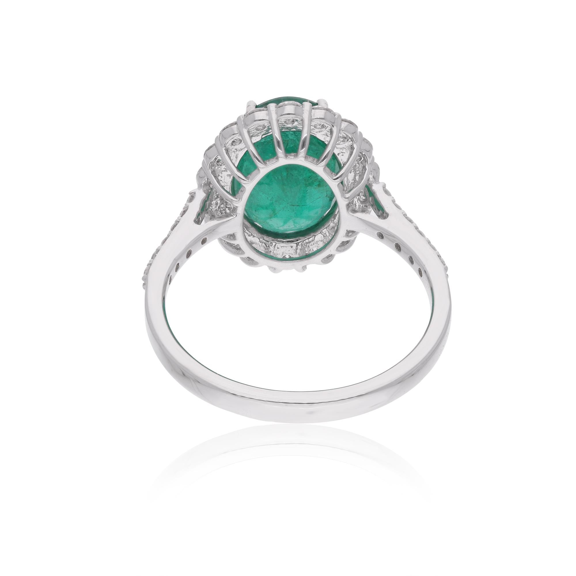 Step into the world of luxury with this breathtaking Zambian Emerald Gemstone Cocktail Ring, crafted in 14 karat white gold and adorned with dazzling diamonds. The centerpiece of this exquisite ring is a captivating Zambian emerald, renowned for its