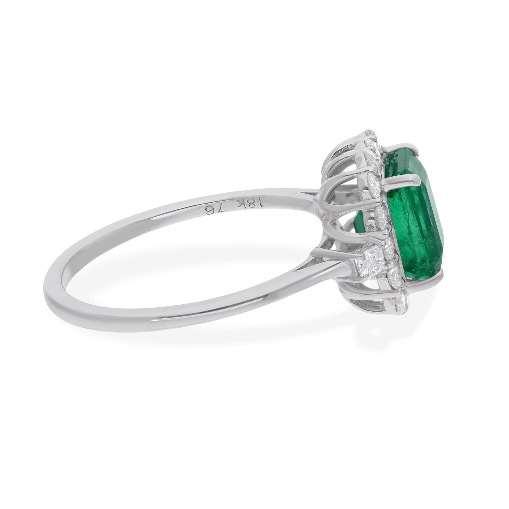 Set in lustrous 14 karat white gold, the emerald is cradled by a halo of dazzling diamonds, each meticulously selected to enhance the radiance of the central gemstone. The contrast between the vivid green of the emerald and the scintillating