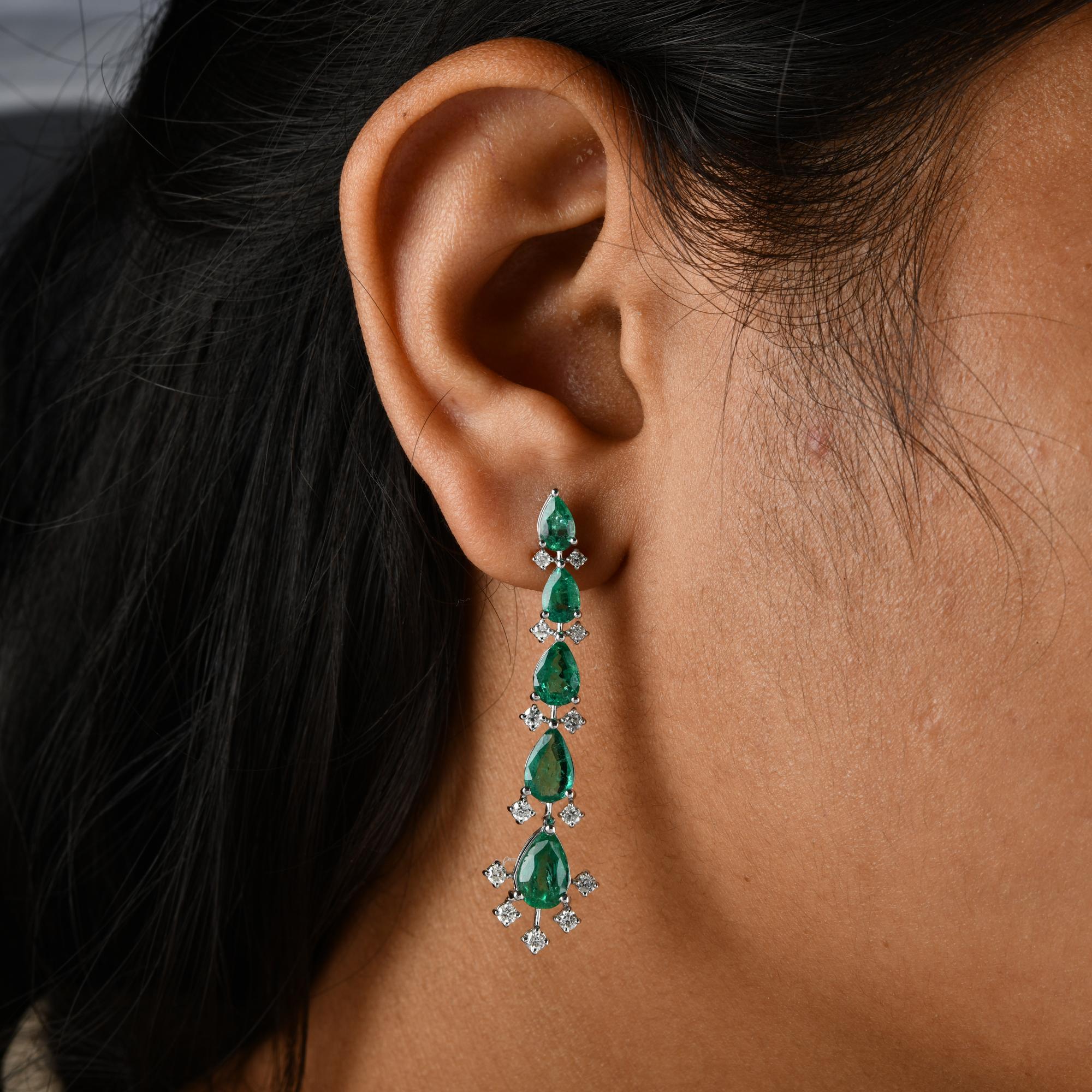 Introducing our captivating Zambian Emerald Gemstone Dangle Earrings, meticulously crafted from 18 karat white gold and adorned with radiant diamonds. These earrings are a mesmerizing blend of elegance and luxury, designed to grace your ears with