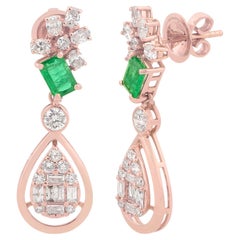 Boucles d'oreilles pendantes en or rose 18k avec pavage de diamants et pierre d'émeraude naturelle.