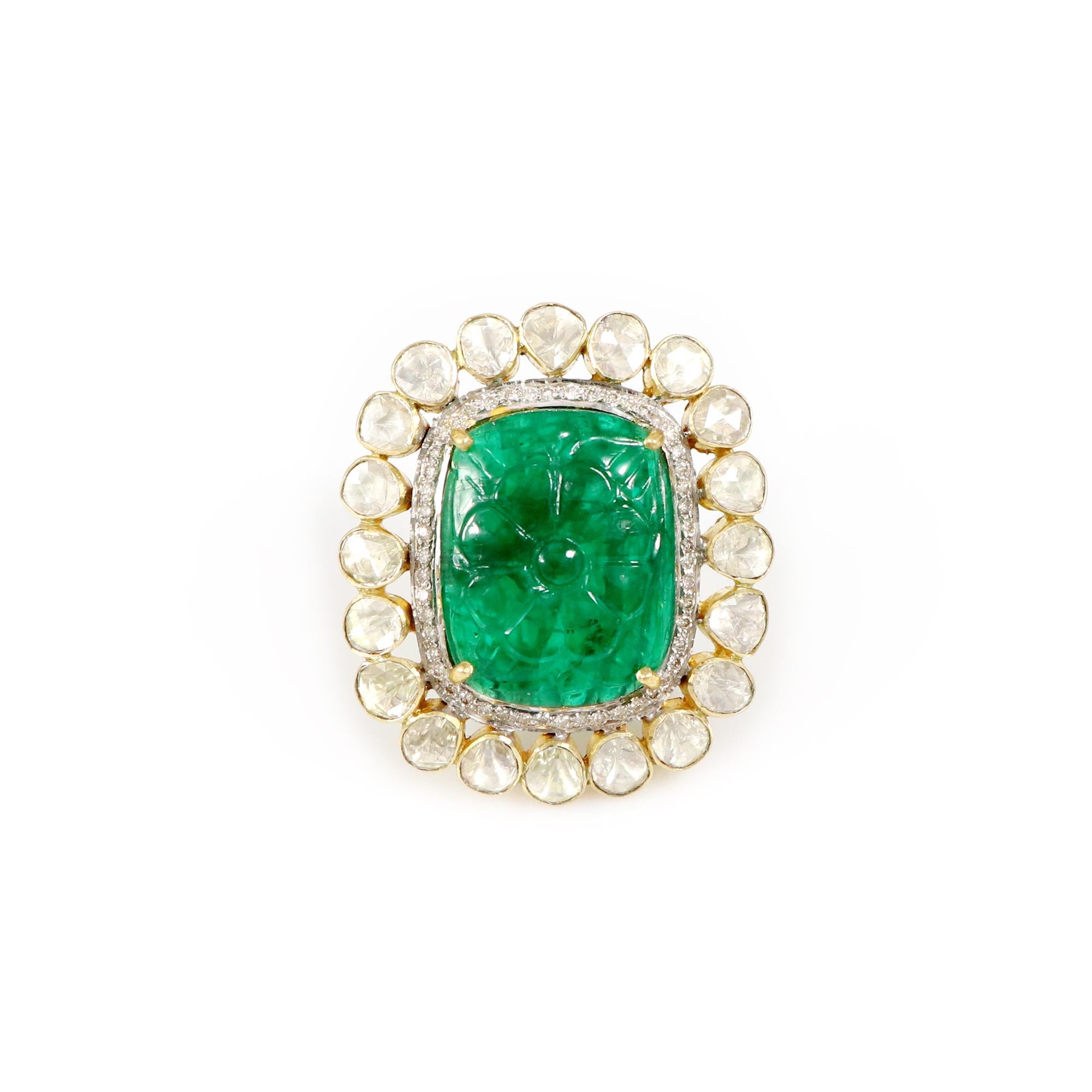 Introducing our exquisite Carved Zambian Emerald Ring, a true masterpiece of luxury and elegance. This stunning piece showcases a meticulously hand-carved Zambian emerald, encircled by uncut diamonds, elegantly set in 18K yellow gold. This creation