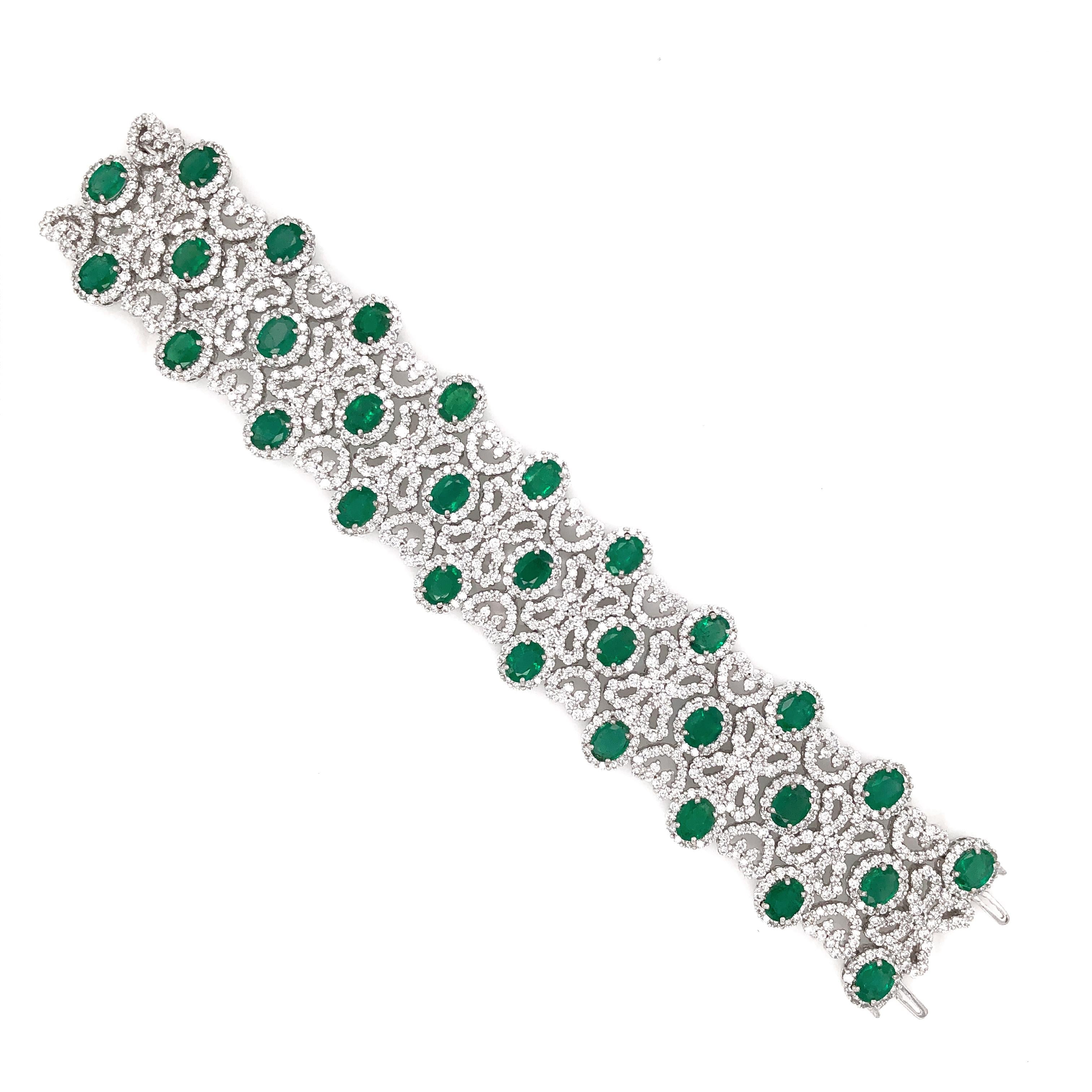 This is a vintage and Art Deco inspired diamond 18 karat gold bracelet.  It is adorned with Zambian oval cut emeralds 22.18 carat total, and white round cut diamonds 20.16 carat total. 
Diamonds are all natural in G-H Color Clarity VS.   18 karat
