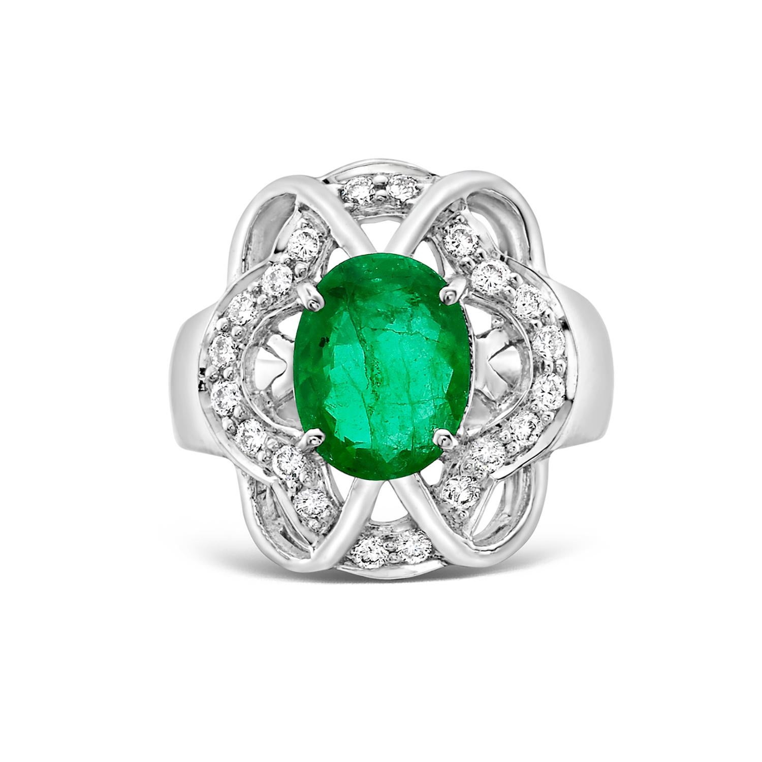 Bring a touch of elegance to your finger with this exquisite Zambian emerald ring. Featuring a beautiful oval shaped emerald surrounded by illusional diamonds set in 18k white gold. The combination of the radiant green emerald and sparkling diamonds