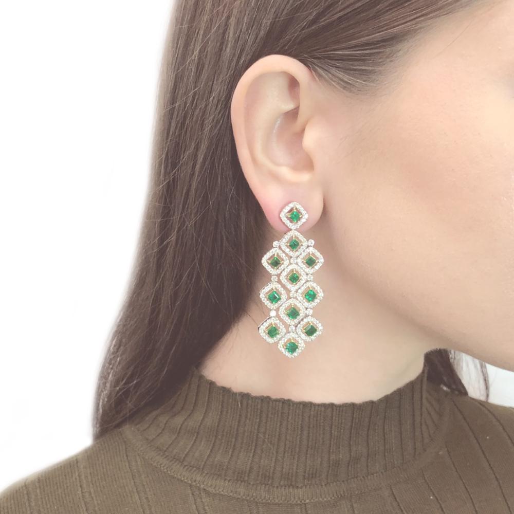 Handcrafted 18 karat white gold chandelier earrings.
Square cut green emeralds 7.11 ct from Zambia.
Accented with small round white diamonds 5.92 ct.
Diamonds are all natural in G-H Color Clarity VS.
French / Omega clips.
Width: 2.5 cm
Height: 6