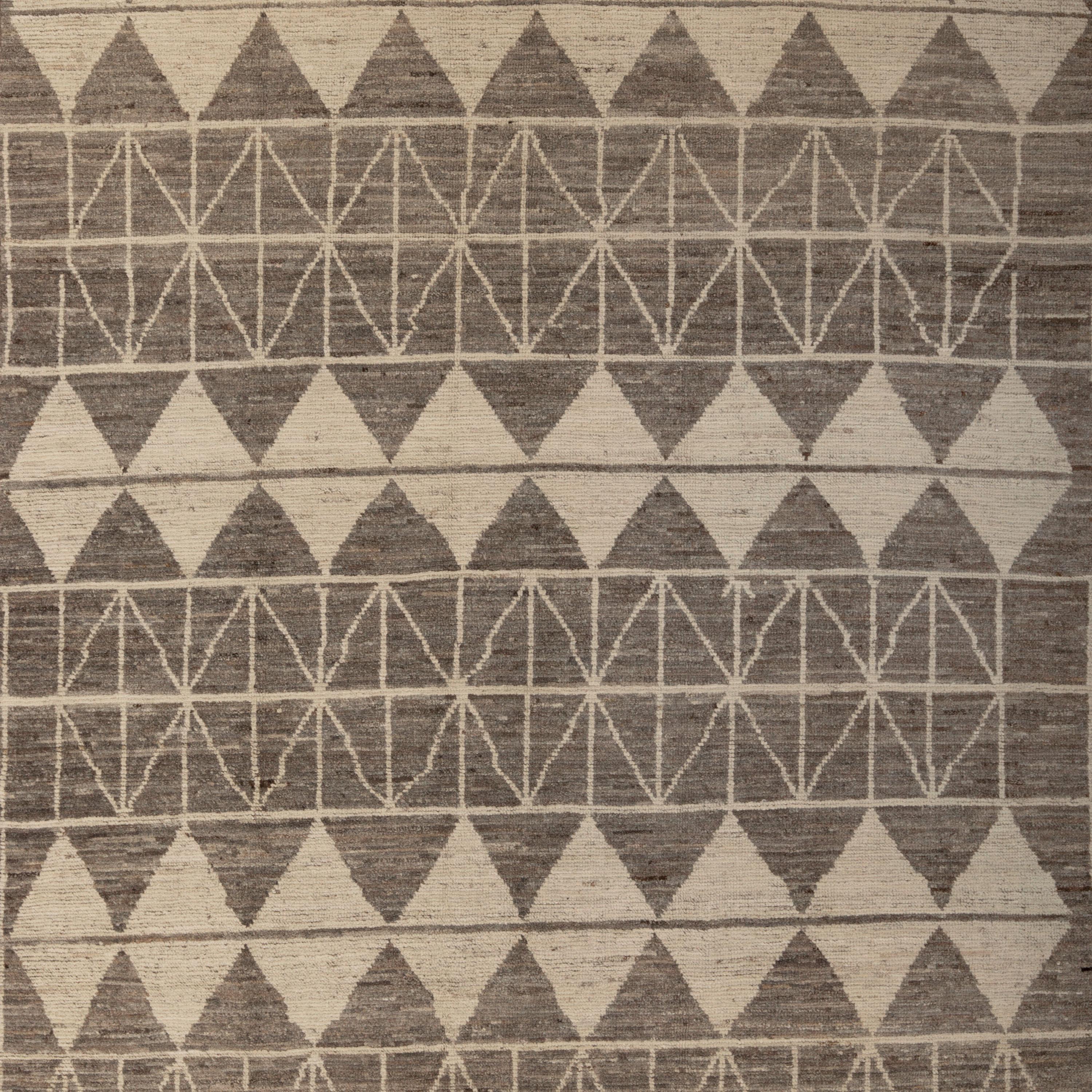 Inspiré par les fondements des couleurs naturelles et des matériaux purs de la Terre, ce tapis géométrique en laine gris et crème Zameen - 6'2