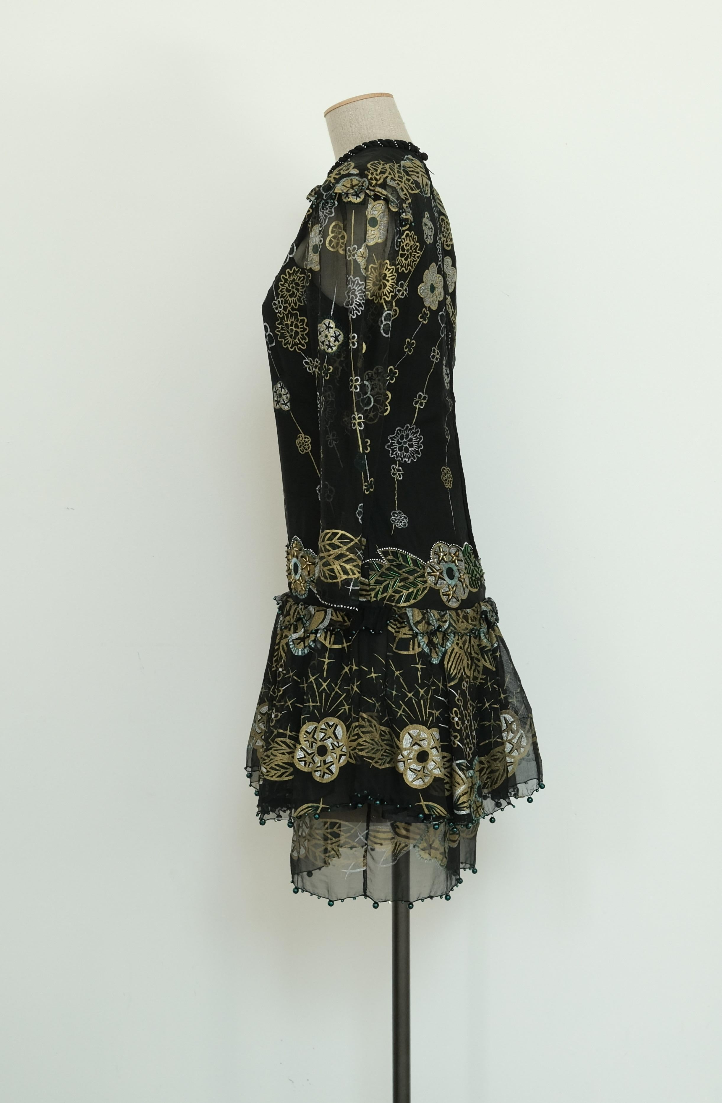 - Zandra Rhodes 
- 80s
- Hand made in England
- UK size 10
- Silk chiffon
- Black with gold and silver hand printed pattern
- Hand embellished with sequins beads and crystals
- Sheer sleeves and front panel
- Teared skirt finished with green beads
-
