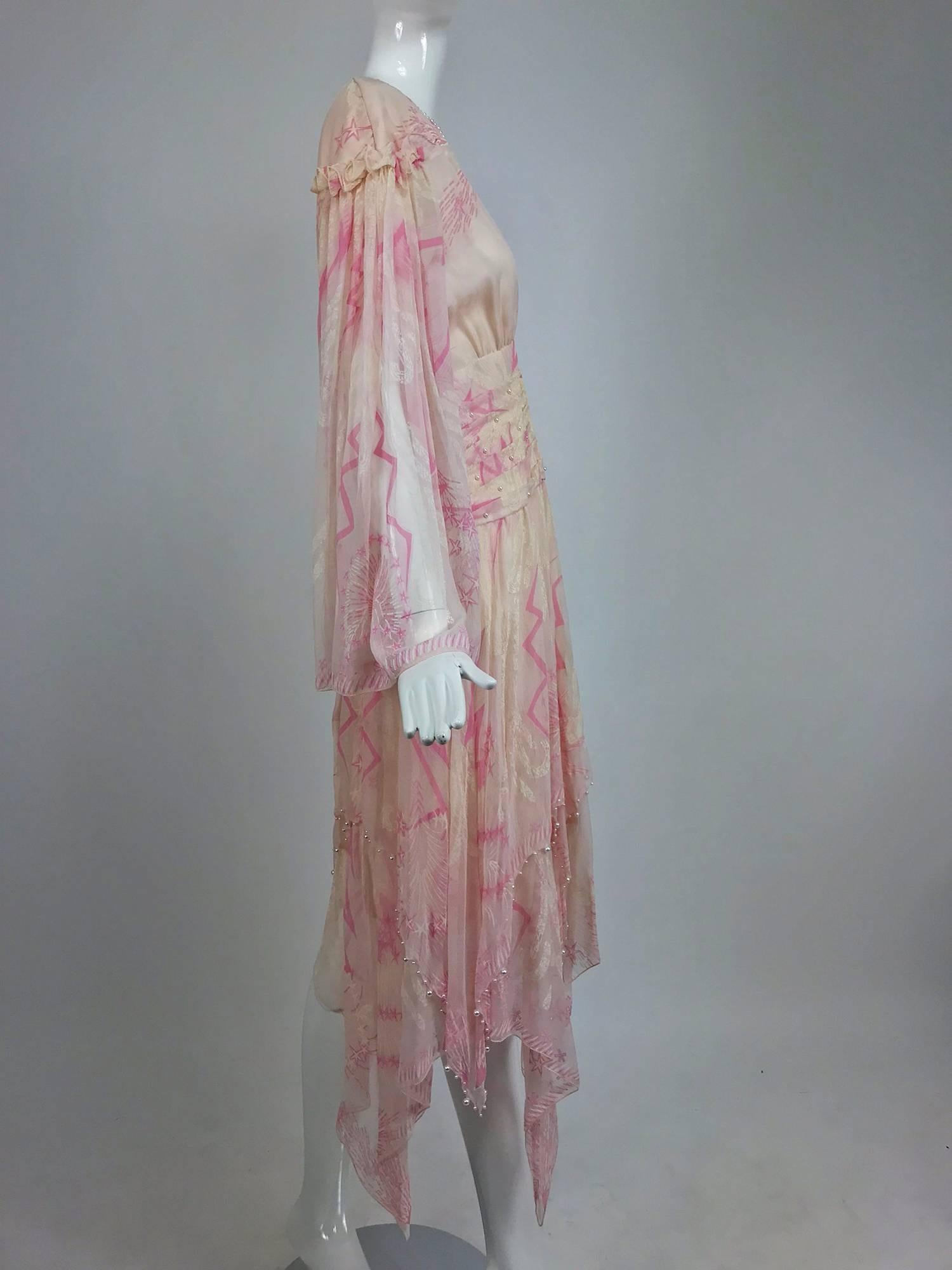Zandra Rhodes cream and pink silk star asymmetrical hem dress 1989...Pale cream chiffon with painted pink stars and lightening bolts cover this full sleeve dress that has a deep V neckline,  wide draped waist decorated with tiny pearls ...The