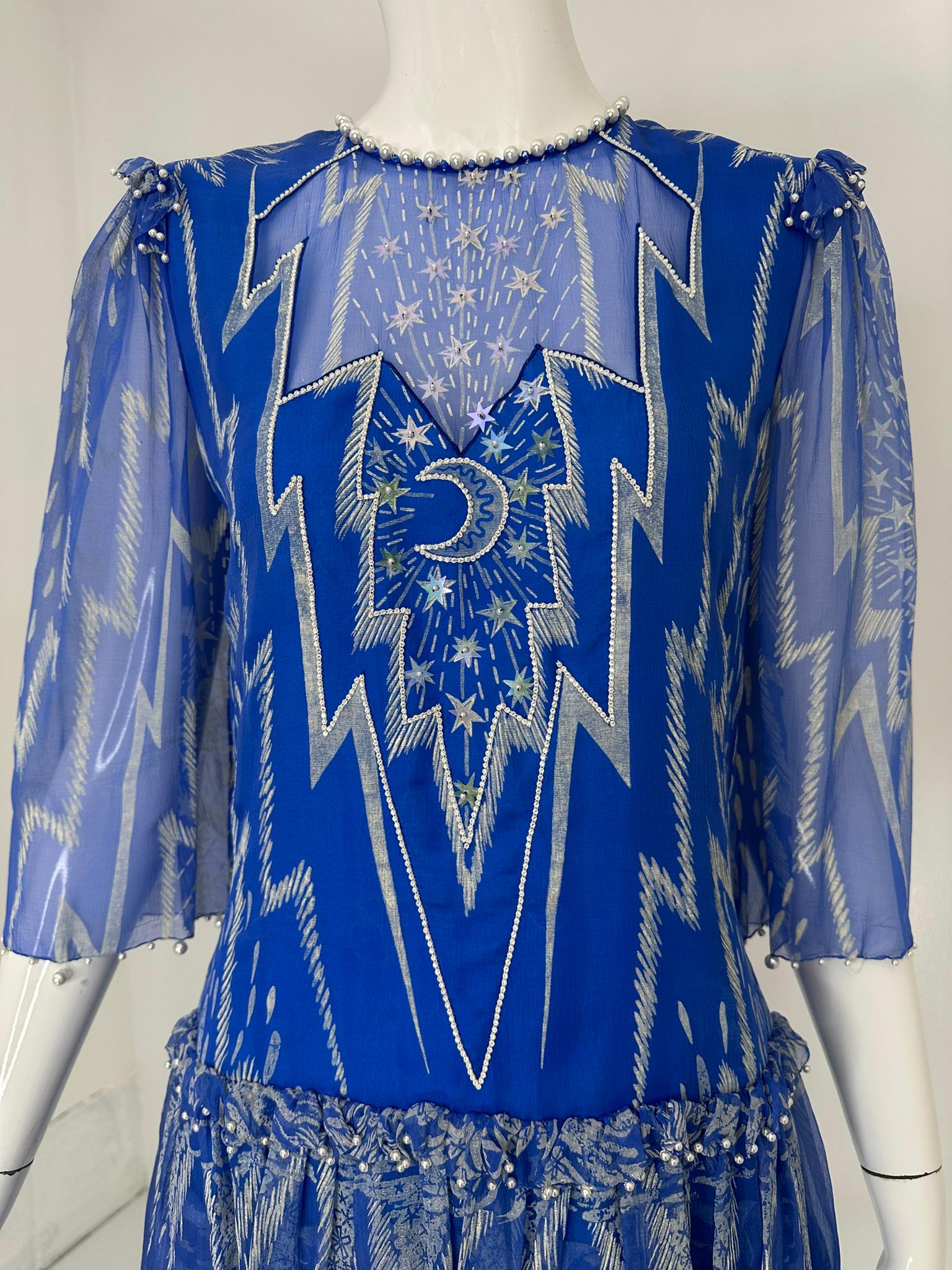 Zandra Rhodes, Londres, vestido luna y estrellas gasa de seda azul brillante estampada a mano en blanco plateado, la parte delantera del corpiño, está cosida a mano con luna y estrellas de lentejuelas y perfilada en pedrería, todo está cosido a mano