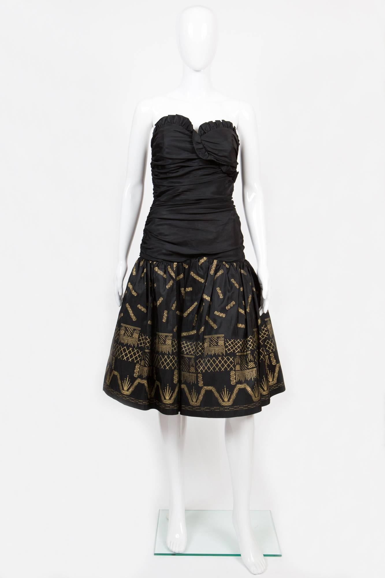 Gorgeous Zandra Rhodes evening dress featuring a silk black taffeta fabric base, with gold metallic paint on the skirt portion, skirt gets an inside a tulle petticoat, a center back zip opening, the top edge is ruffled and cuts through the middle,