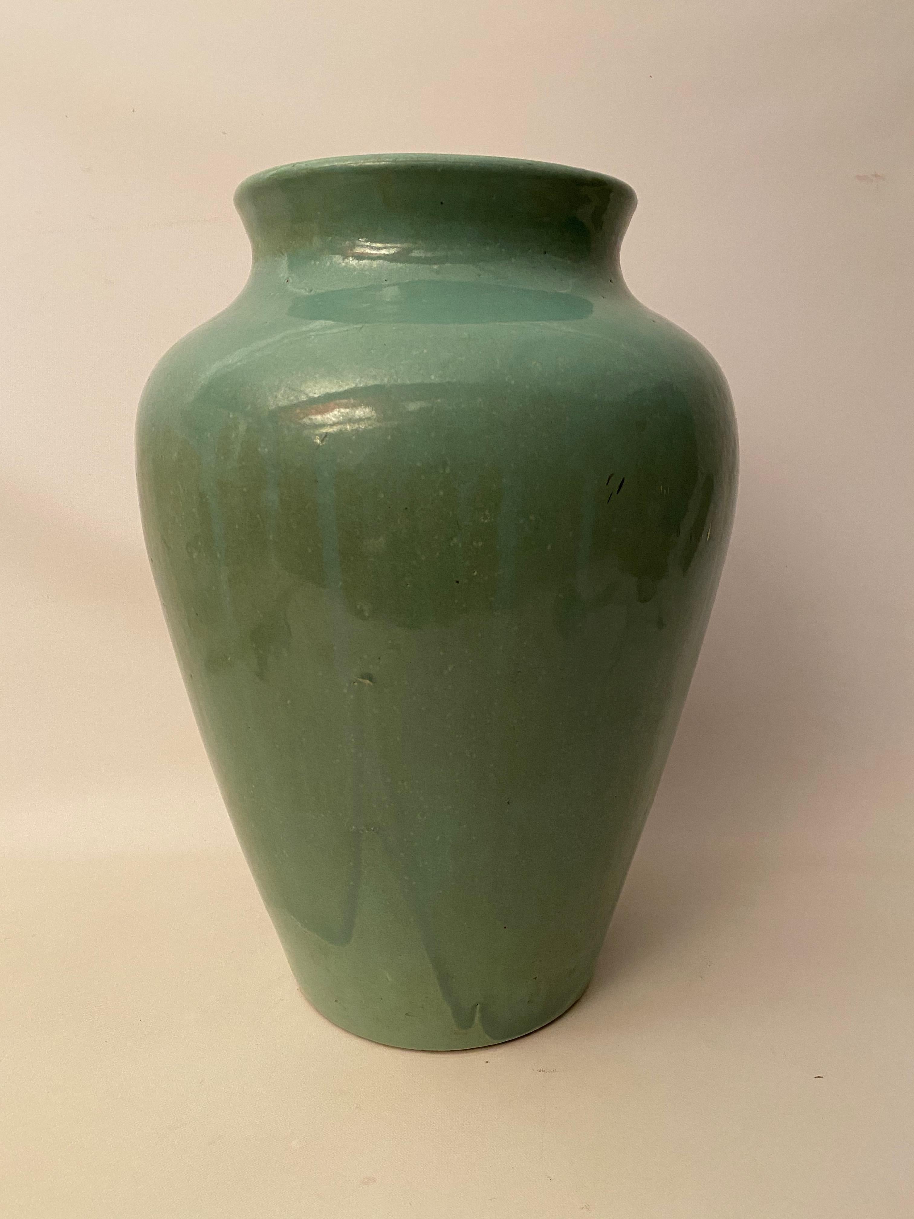 Large blue on blue drip glaze stoneware amphora oil jar for Zanesville, Ohio Stoneware Company, circa 1930. The pot still retains a partial label (see photo). Very good condition with no visible cracks, hairlines, crazing or restorations. There is
