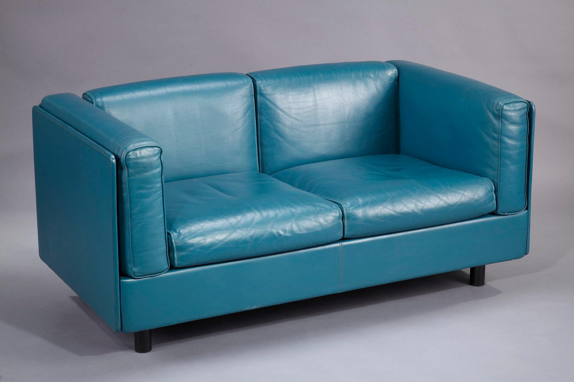 Zanotta monobloc sofa, entirely covered with full grain blue leather, resting on four black lacquered metal legs. The seat is composed of six independent cushions. Removable cushions and removable cover in leather. This vintage sofa was manufactured