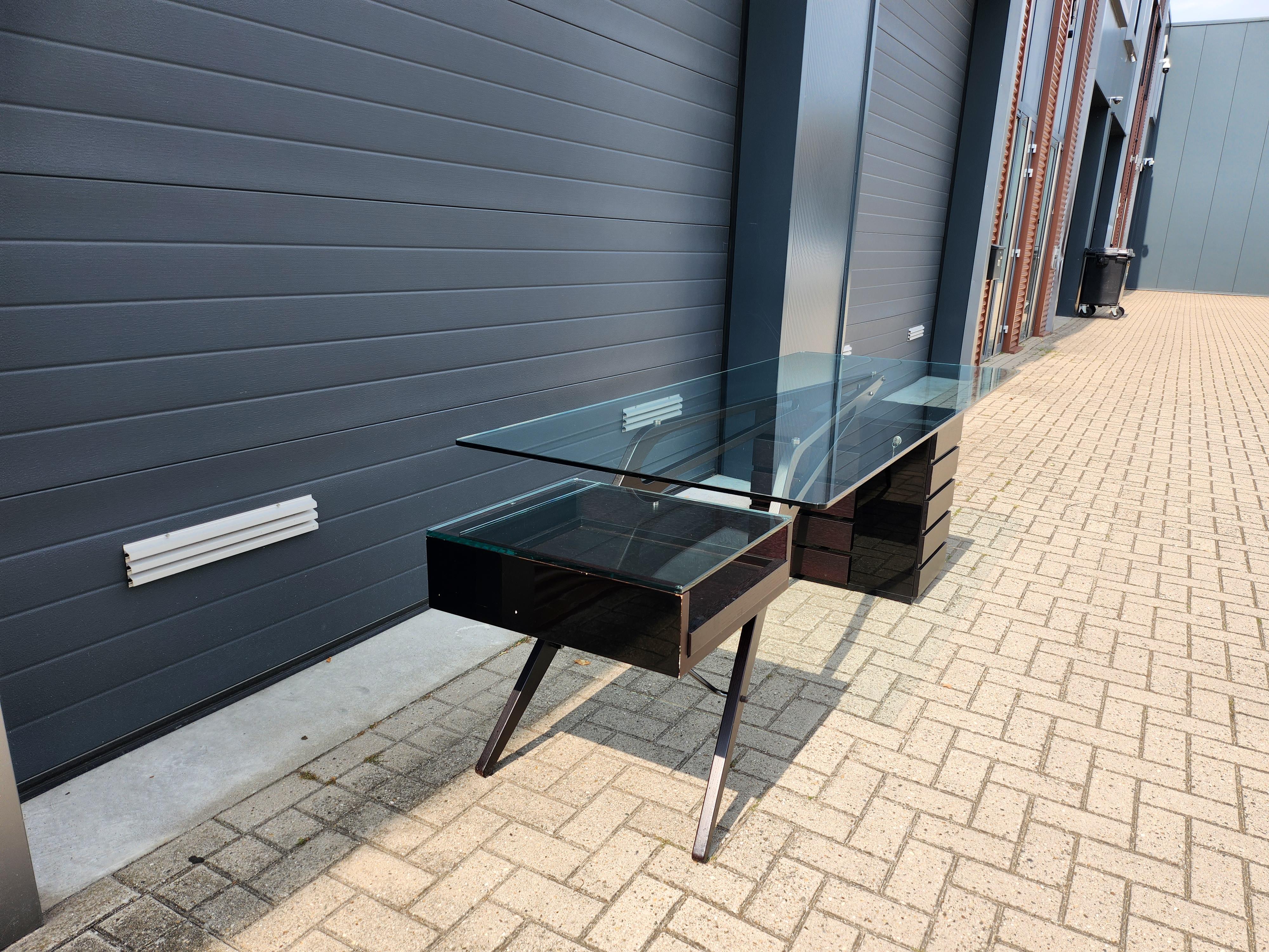 (in used but good condition, small scratches on the glass and signs of use).

The Zanotta Cavour CM Desk is a design from 1949 by the eccentric Italian designer and architect Carlo Mollino. This desk is one of the results of Mollino's search for the