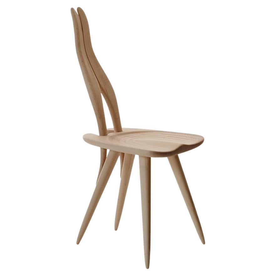 Chair. Frame in natural or black painted solid maple wood.
Every epoch has its art
A chair that is a sculpture: entirely carved out of solid maple, its back rests on the legs creating a game of elegant joints, in the continuity of the