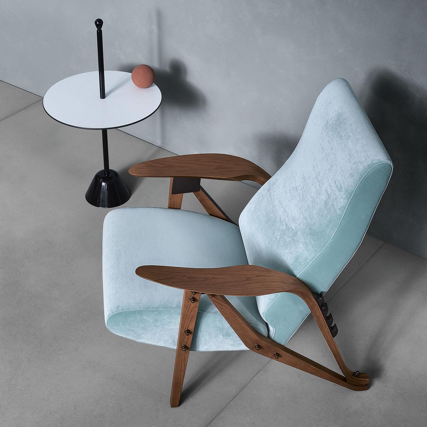 A reclining armchair with four positions, which represents Mollino's eclectic style, seeking ergonomics and comfort. 
Details and elegance: shaped solid wood and a single element that joins the legs and the cozy armrest, similar to a leaf, large