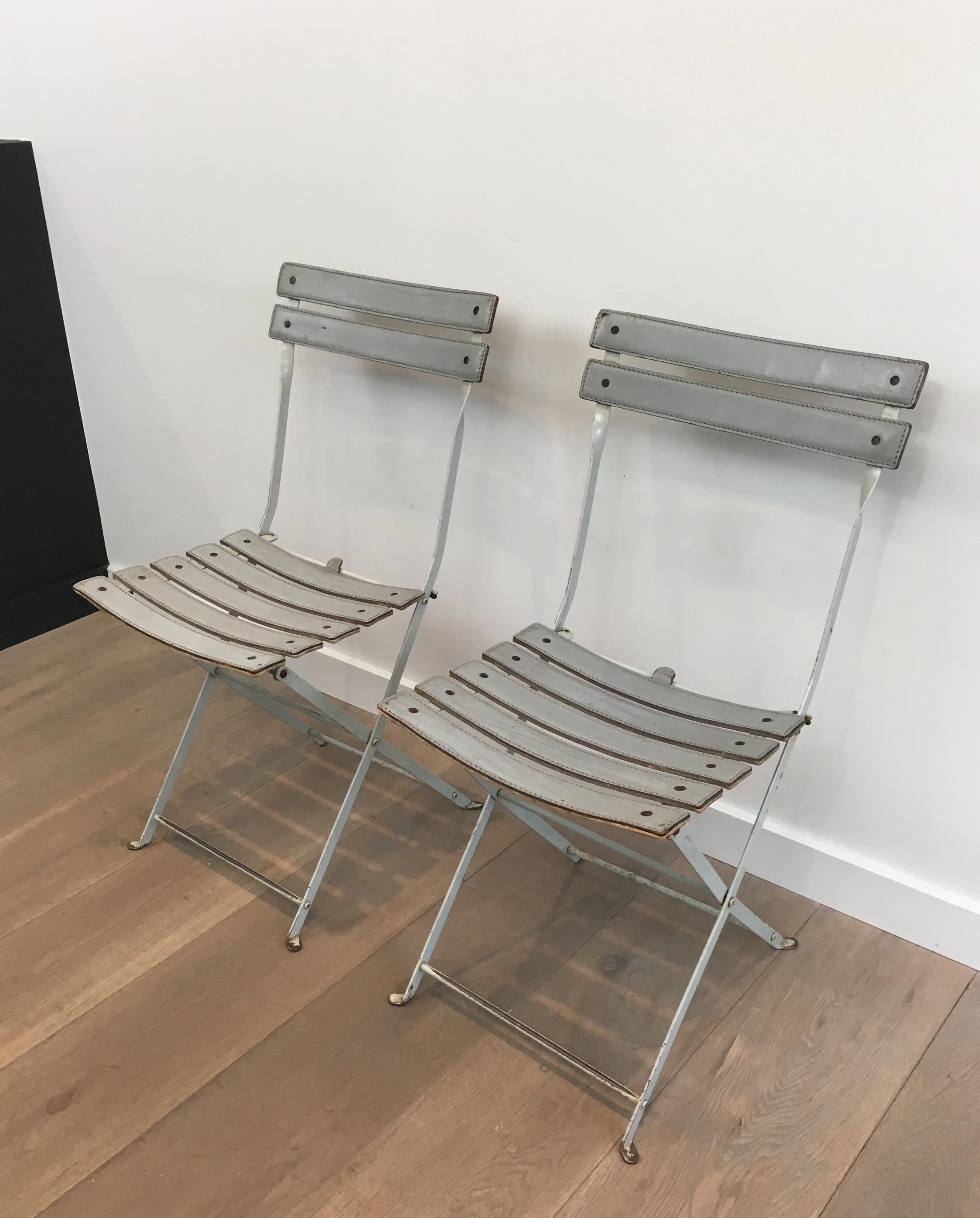 This pair of folding chairs is made of white lacquered metal with a grey leather seat and back. These are comfortable and easy to store as they can be fold. These chairs are Italian, attributed to Zanotta, circa 1970.