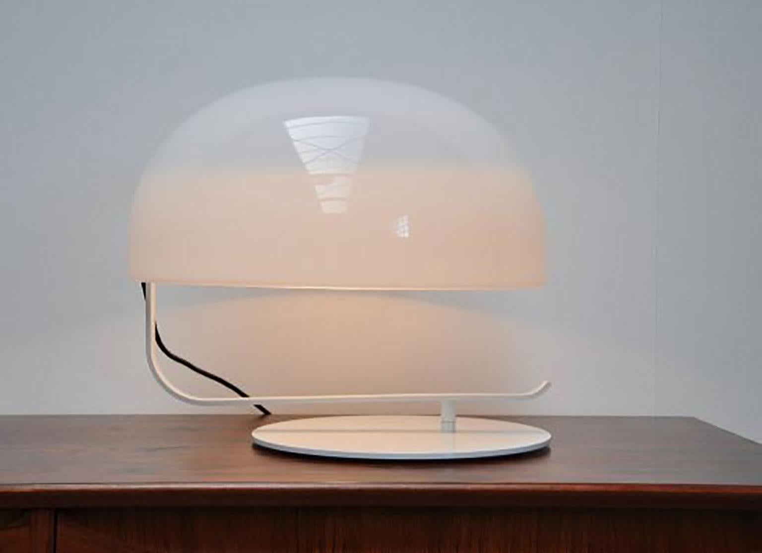 La lampe de table Zanuso a été conçue par Marco Zanuso Soto pour Oluce. Classique, cette lampe, née en 1963 sous le nom de Modèle 275, se distingue par son grand diffuseur rotatif en Perspex réglable, fixé à une base en métal laqué. Même si elle a