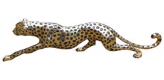 Scultura di ghepardo d'oro che insegue