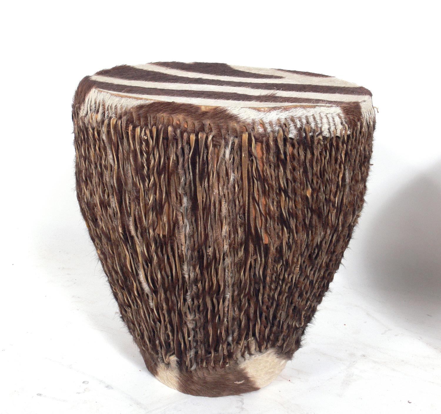 African zebra hide drum end tables, circa 1950s. They are each hand made and unique, and therefore vary slightly in size. From left to right, they measure 13.5