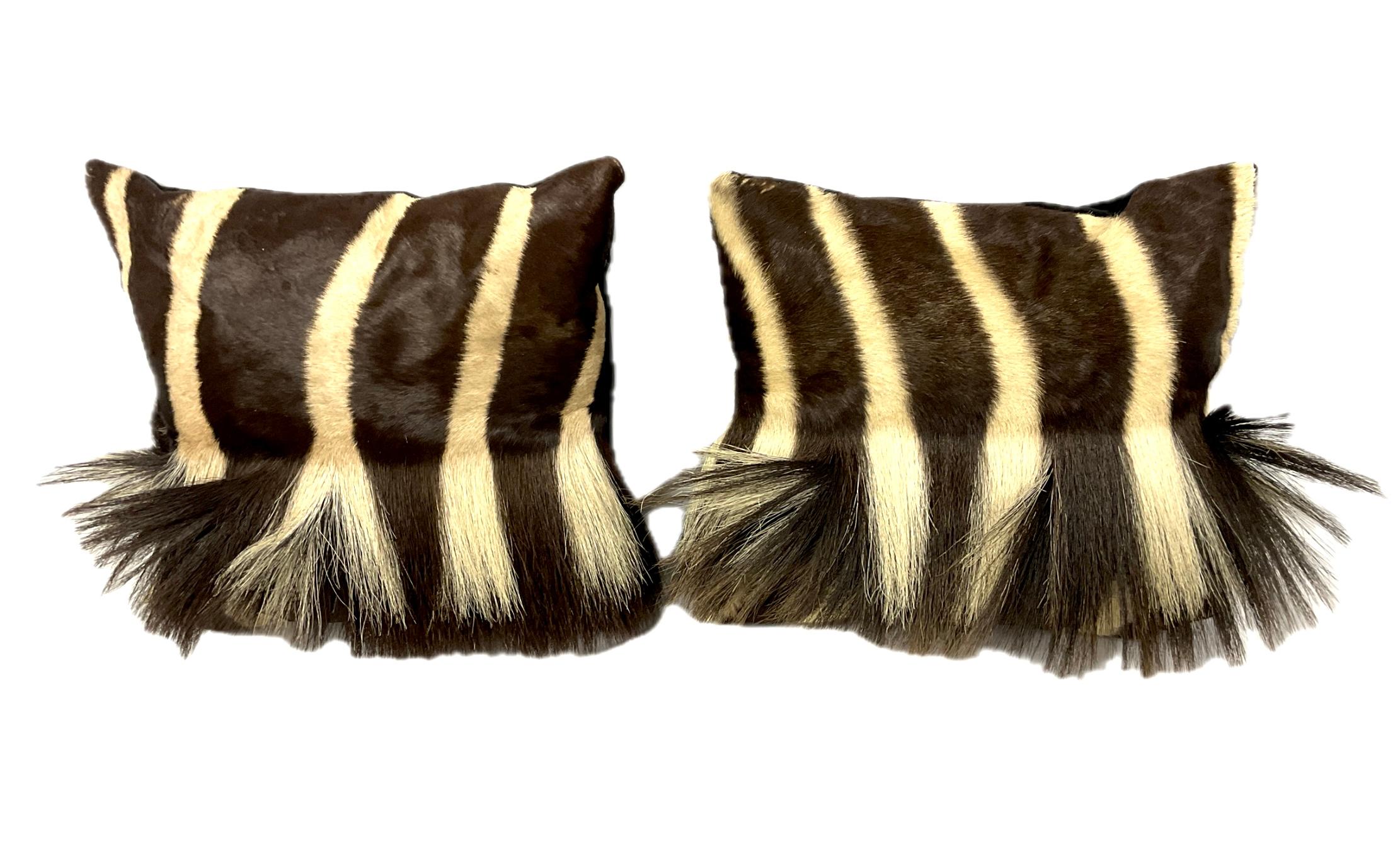 20th Century Genuine Zebra Hide Throw Pillows With Tail Accent, and will make a rare and eye-catching accent for sofas, chairs or beds. Pillows feature striking black and white striping with distinctive tail accents. No two pillows are exactly